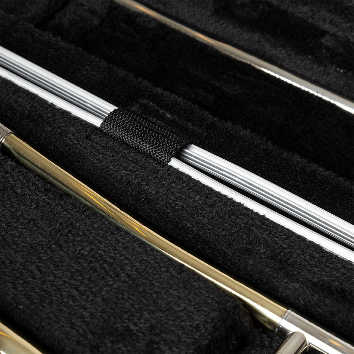 Stagg ABS-TB ABS case for trombone: close-up of the black plush interior with the trombone slide and strap