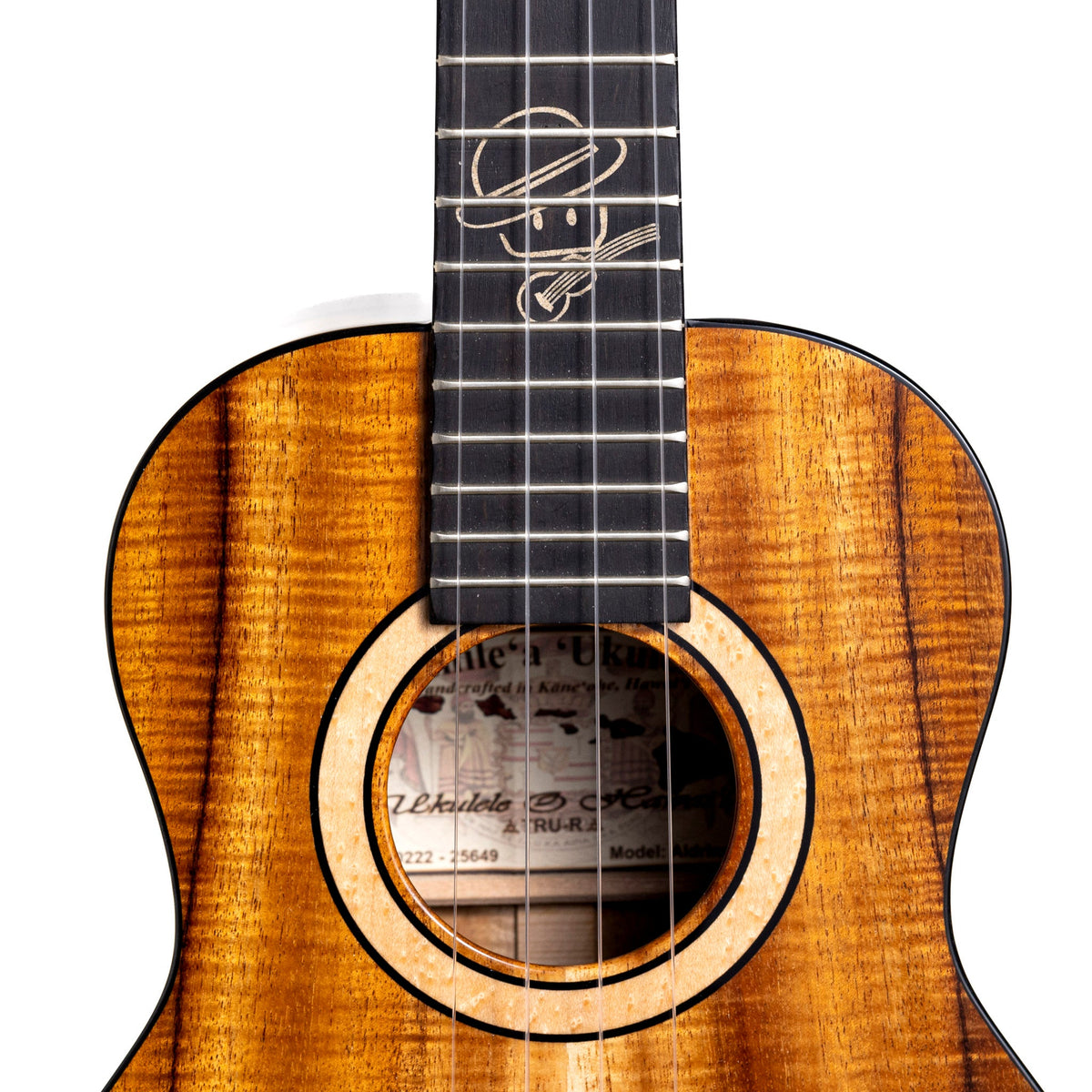 Example photo: an earlier Kanile'a Aldrine tenor, serial 25649, soundhole and fretboard with the Aldrine avatar inlay in Kailua beach sand