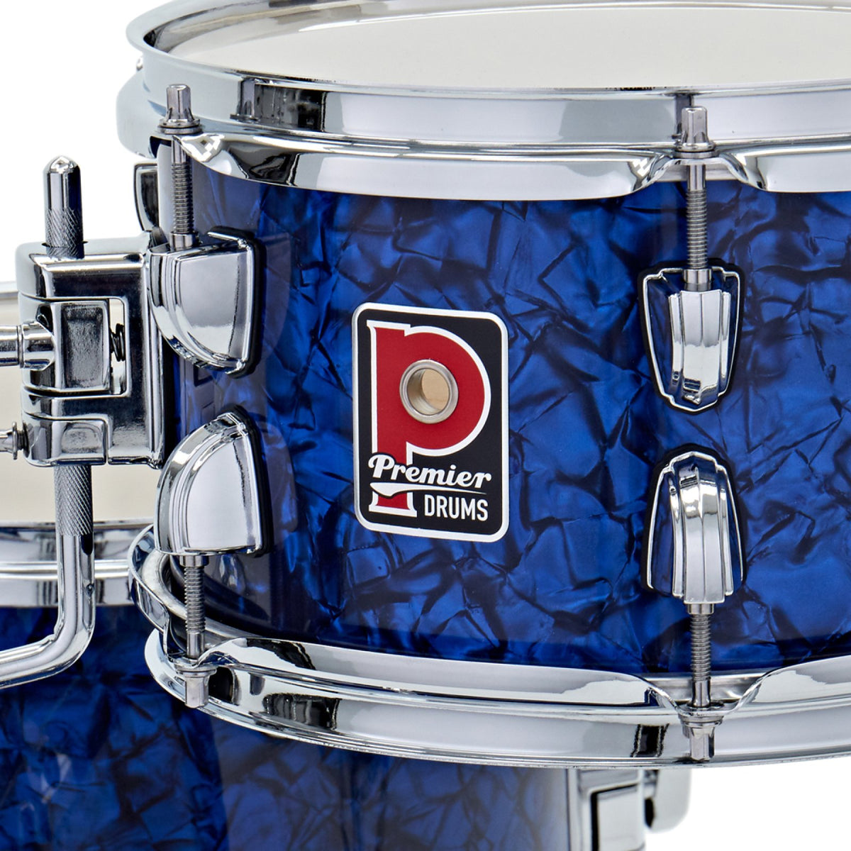 Close-up of the Premier badge and chrome tension lugs on a drum from the Premier Artist Heritage 20-inch 4-piece shell pack in Blue Pearl