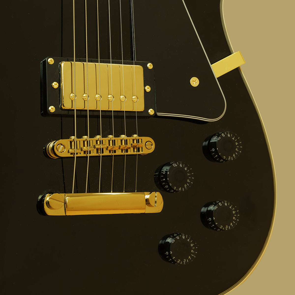 Close-up of the gold-cover humbucker, tune-o-matic bridge, tailpiece and control knobs on the black Stagg 30th Anniversary Legacy guitar