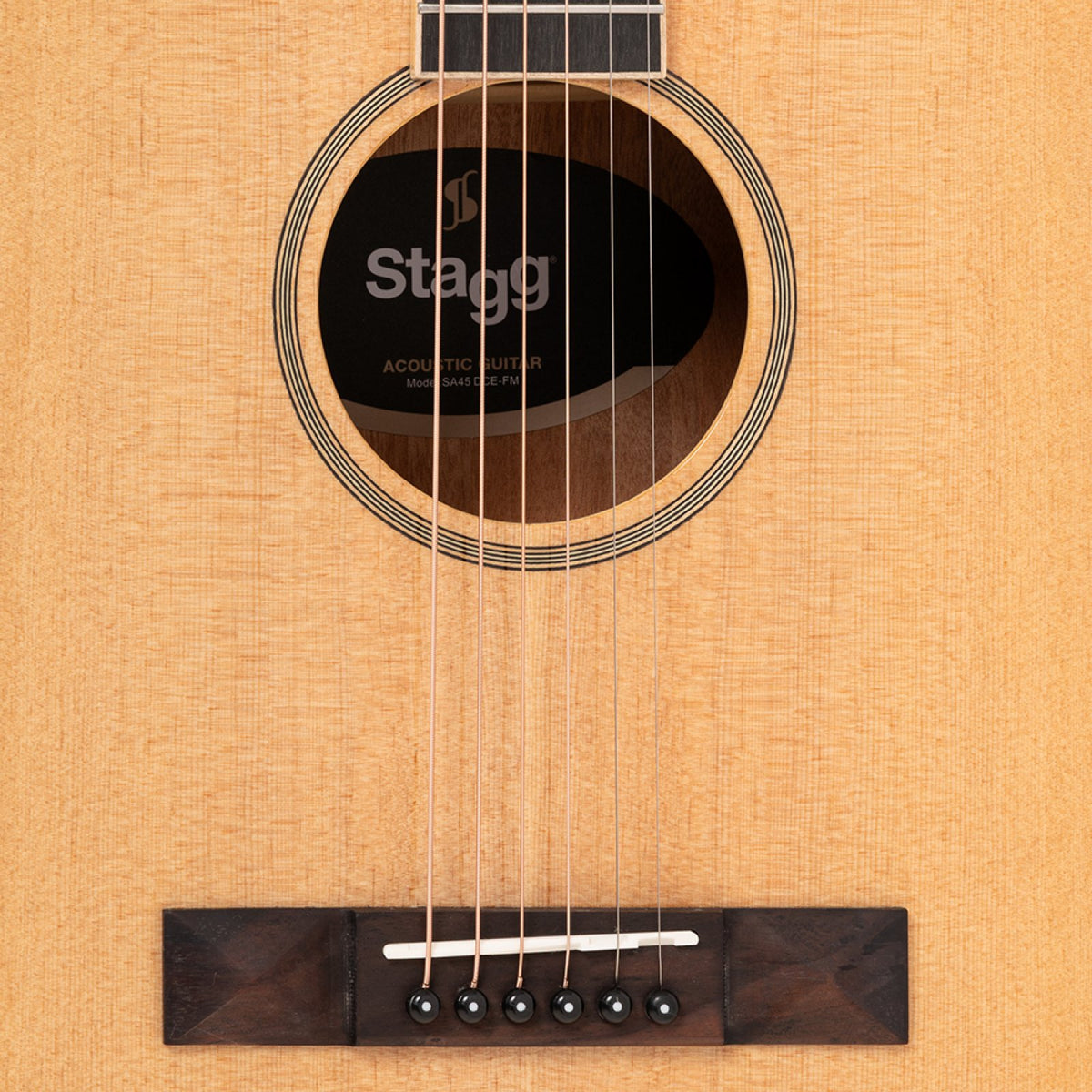 Close-up of the soundhole and rosewood bridge on the Stagg SA45 DCE-FM guitar