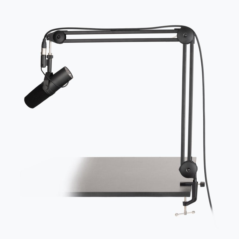 On-Stage MBS7500 black studio mic boom arm clamped to a desk, shown holding a microphone