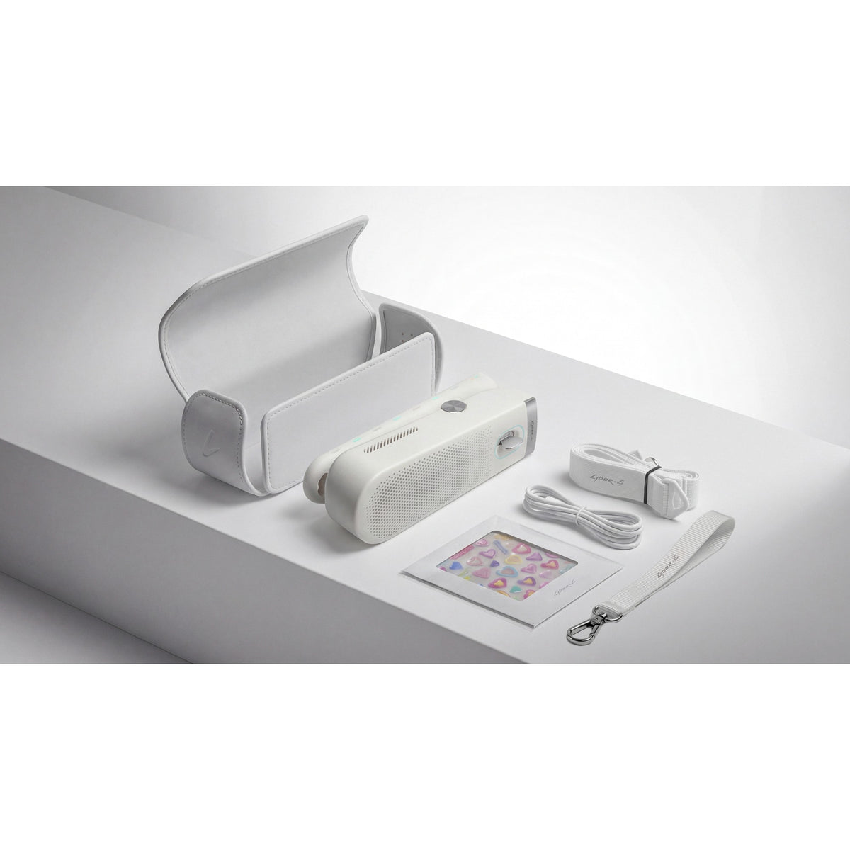 Enya Cyber-G Pocket box contents: premium case, Pocket, charging cable, hand strap, shoulder strap and stickers, shown in White