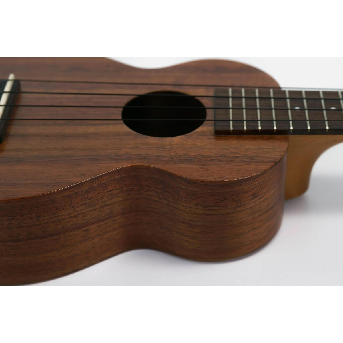 Kamaka HF-1 soprano ukulele close-up at an angle of the soundhole, rosewood fretboard and koa body edge