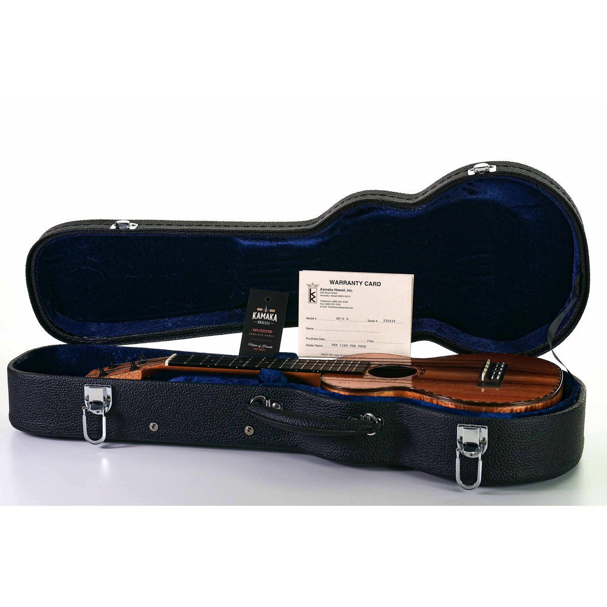 Kamaka HF-2-D concert ukulele in its open black Kamaka hardshell case with blue lining and warranty card