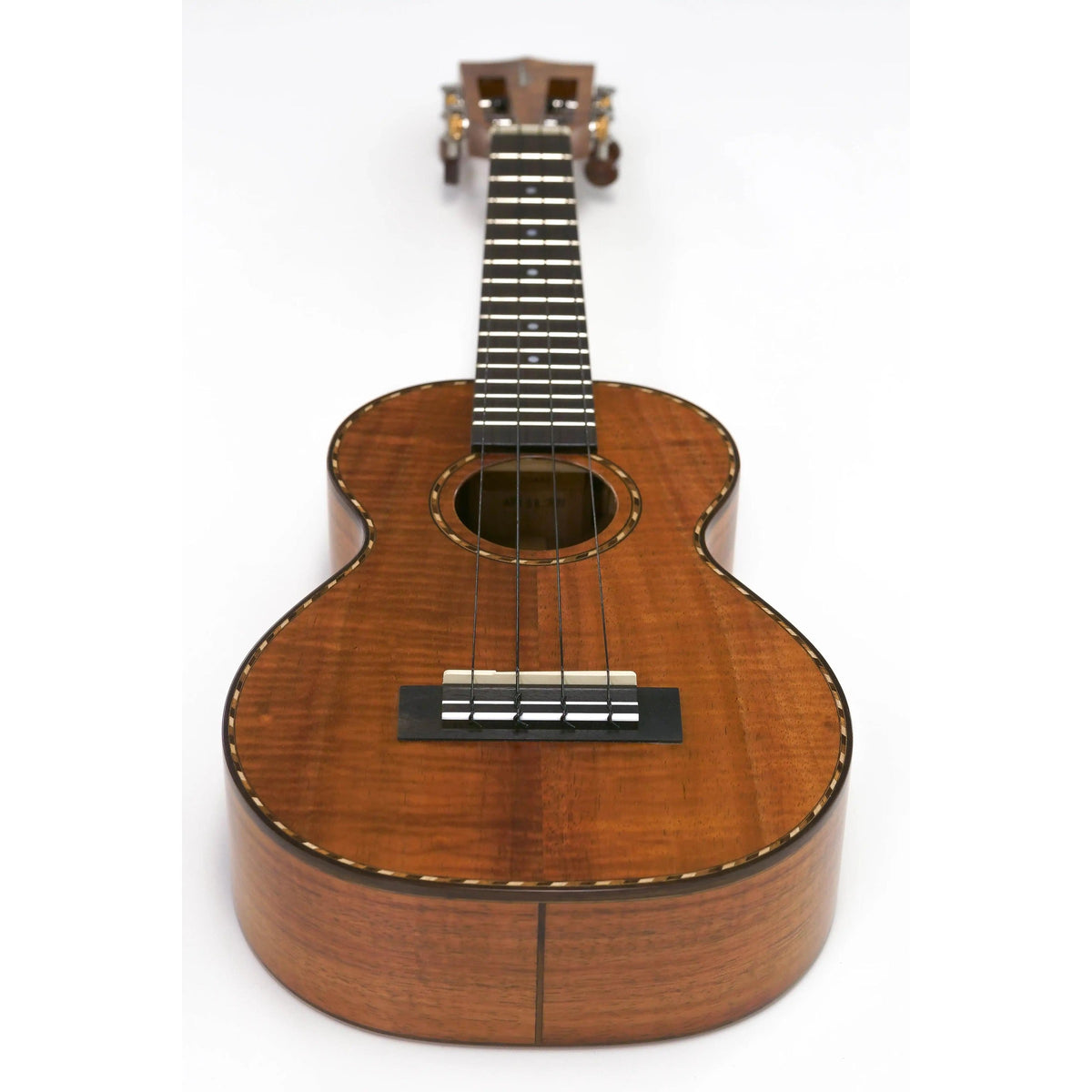 Kamaka HF-2Di concert ukulele full view at an angle showing curly koa top, rope purfling and ebony bridge