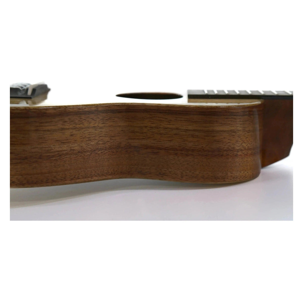 Example photo: side view of a KoAloha KCNP-00, the gloss version of the KCNP-10 Naupaka concert in koa and mango, lying on its side to show the body depth