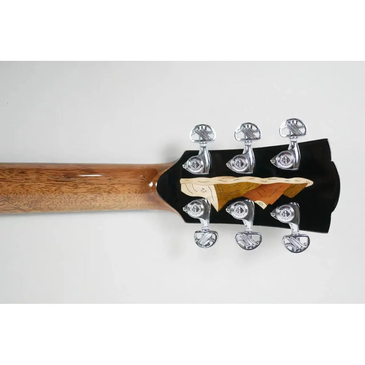 Mérida SPRING-EQ acoustic-electric guitar headstock with golden tuners and a decorative inlay.