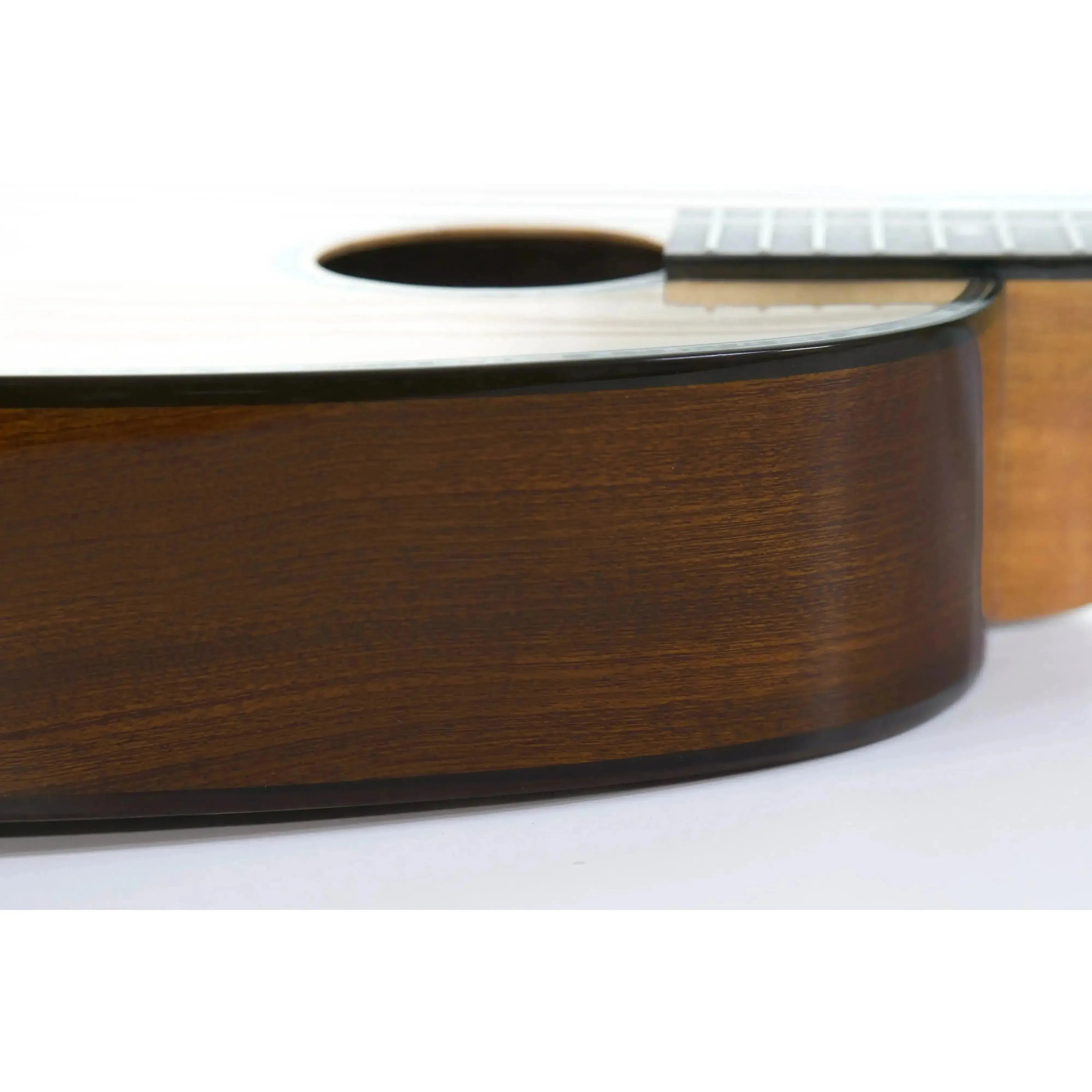 Ohana PKT-70G Pineapple Tenor Ukulele, close-up of dark mahogany side with light spruce top.