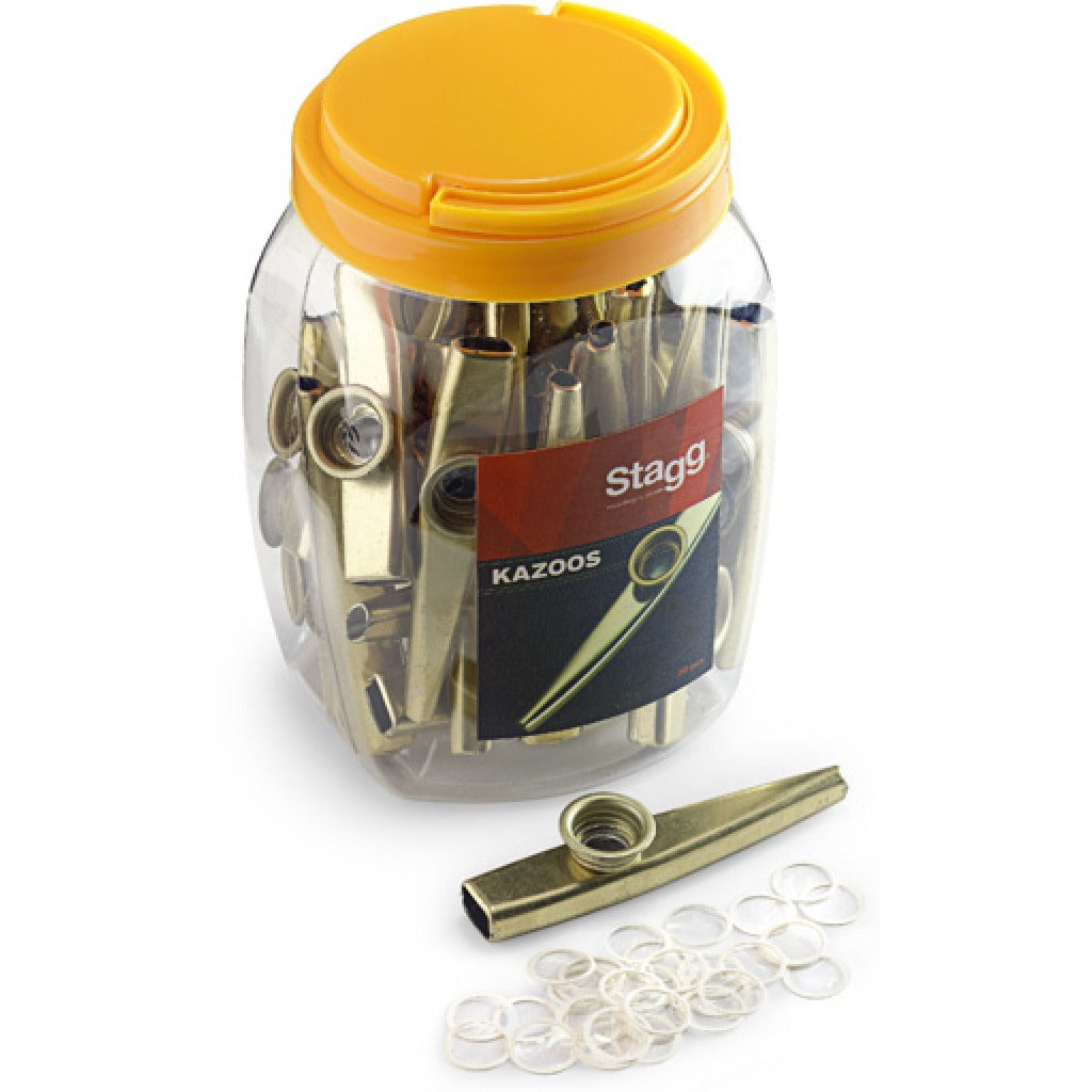 Stagg box of 30 golden metal kazoos in a clear jar with a yellow lid, with one kazoo and spare membrane rings in front
