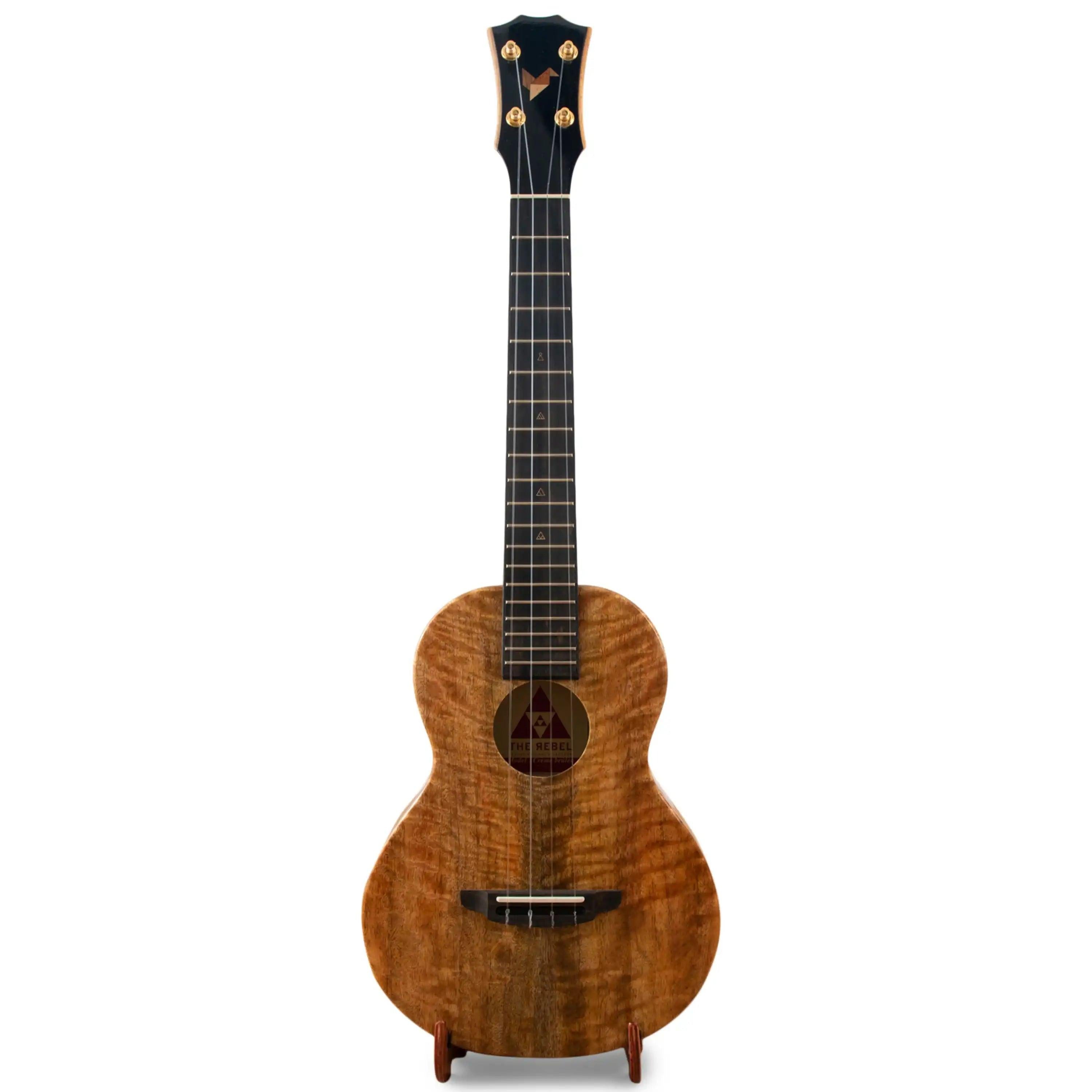 The Rebel Koa ukulele with natural wood grain, featured at Terry Carter Music Store.