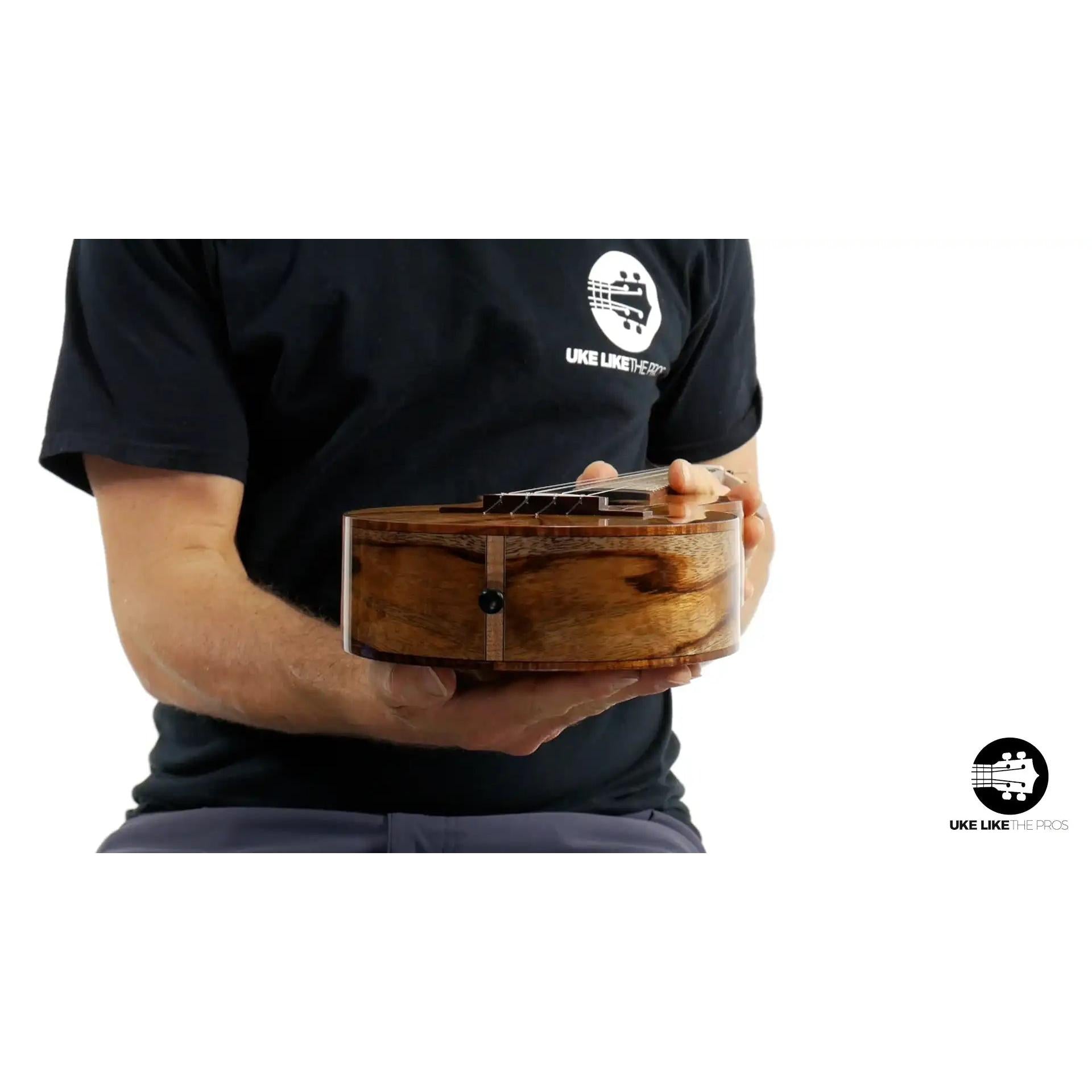 Chocolate Heart ukulele with figured wood body held by person, Terry Carter Music Store