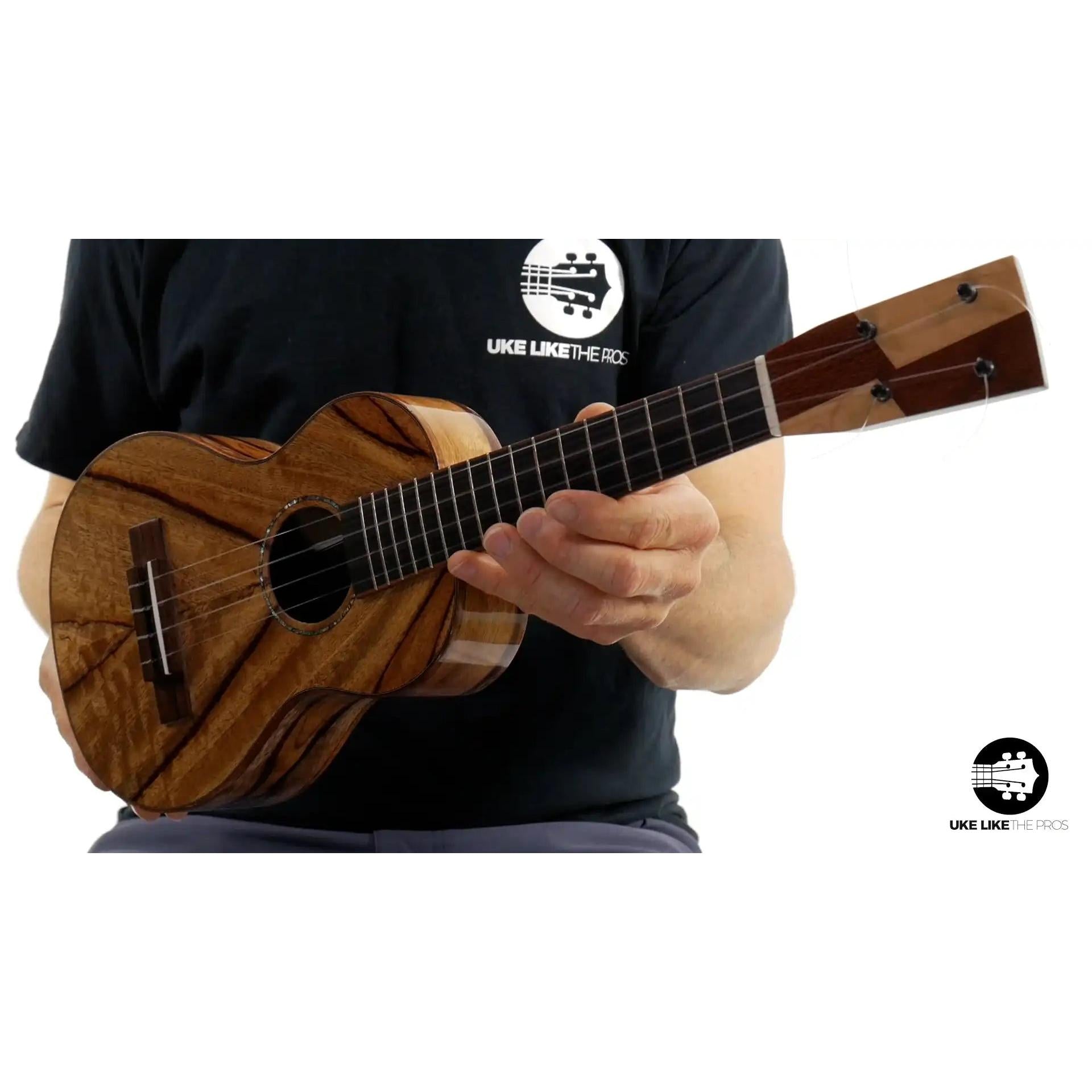 Mya-Moe ukulele with chocolate heart wood top held by musician, Terry Carter Music Store