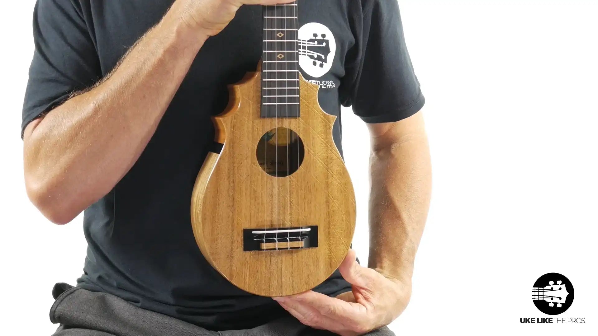 Unique natural wood ukulele with carved edges, held upright, Terry Carter Music Store product photo