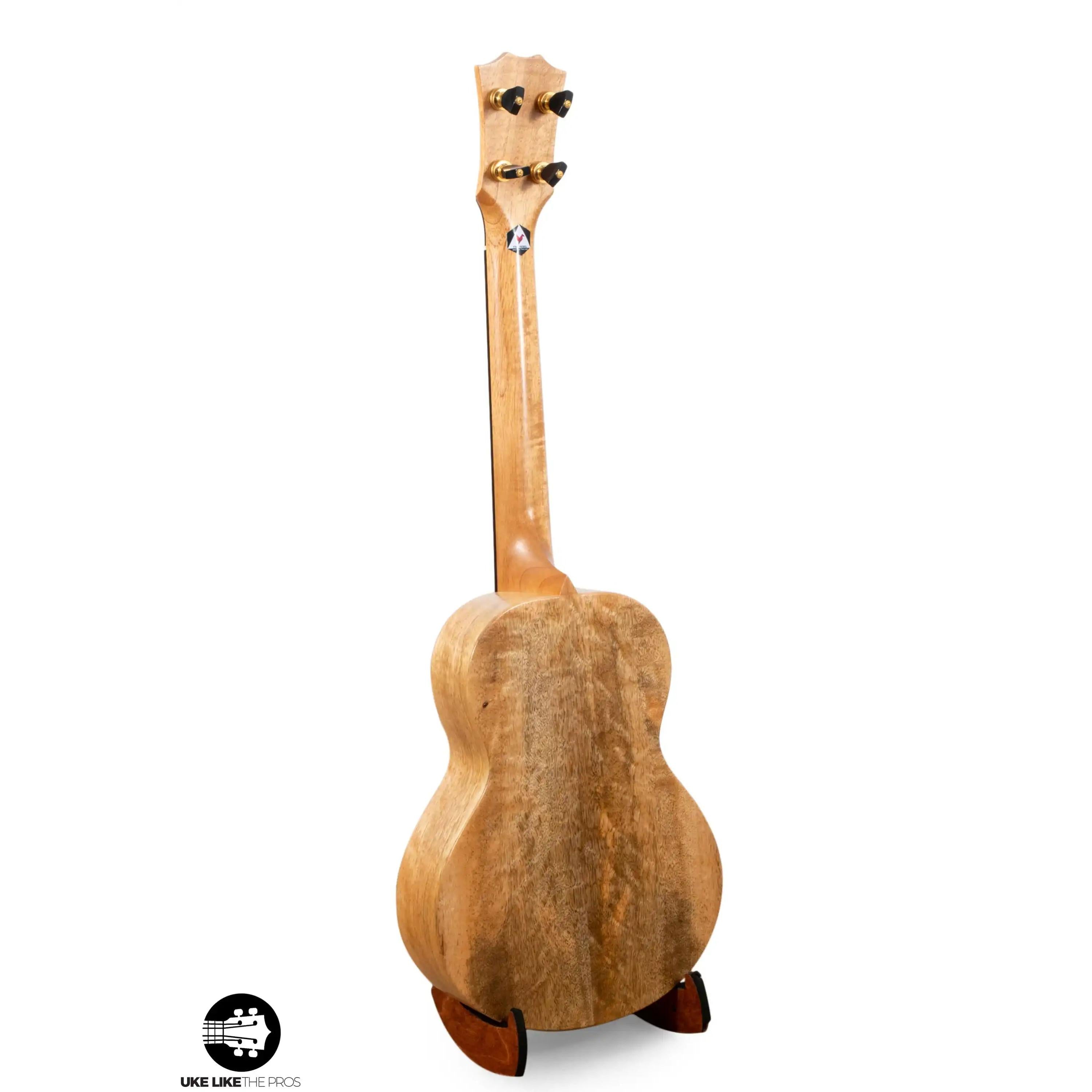 Romero Creations Bearclaw ukulele with natural wood grain back on stand at Terry Carter Music Store