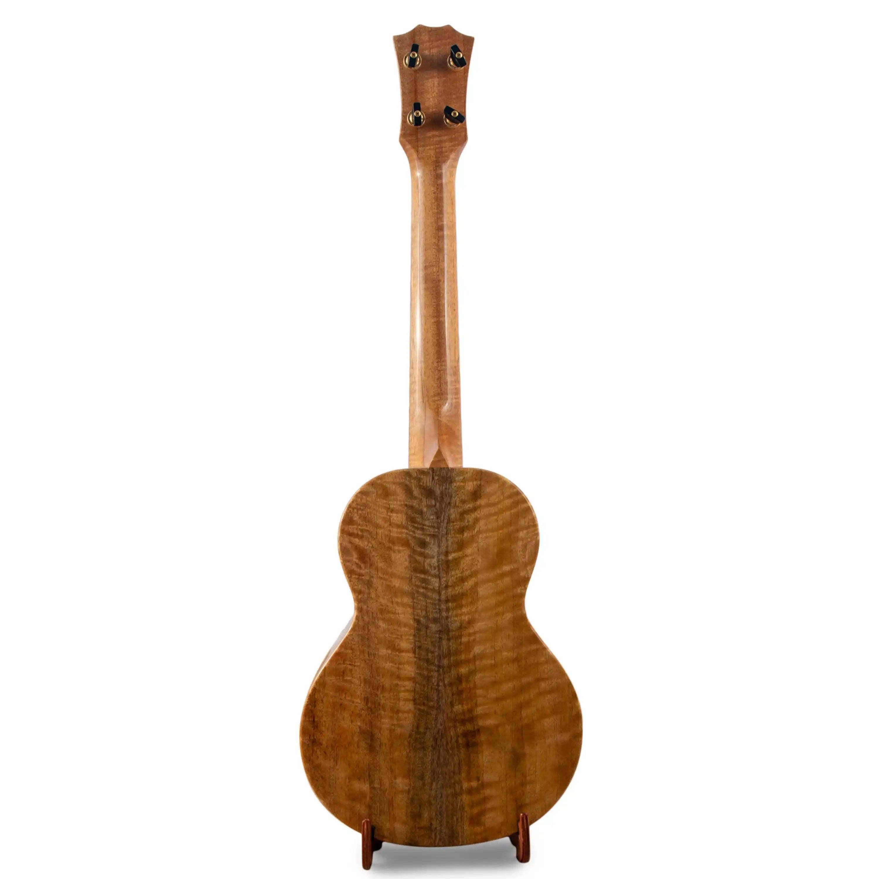 Curly wood back of a ukulele on stand, natural finish, at Terry Carter Music Store.