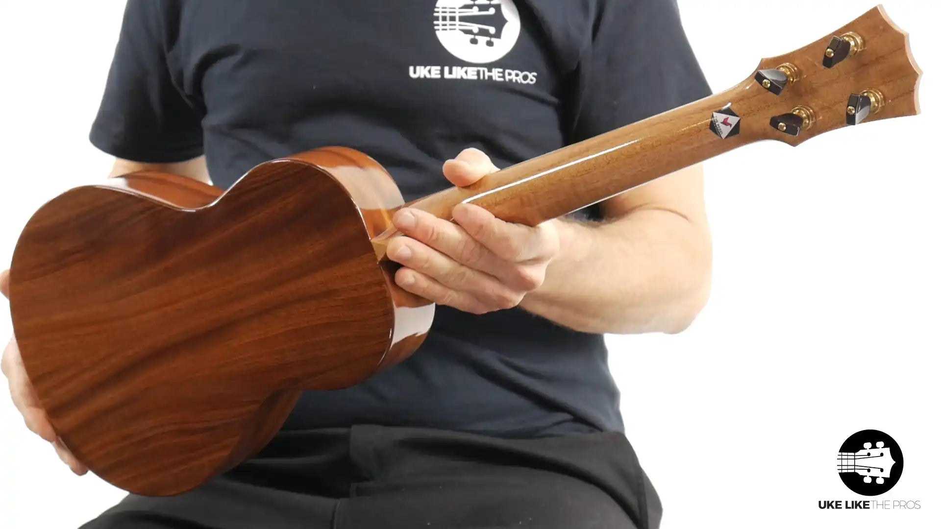 Back of a mahogany tenor ukulele held by a person, featured by Terry Carter Music Store.