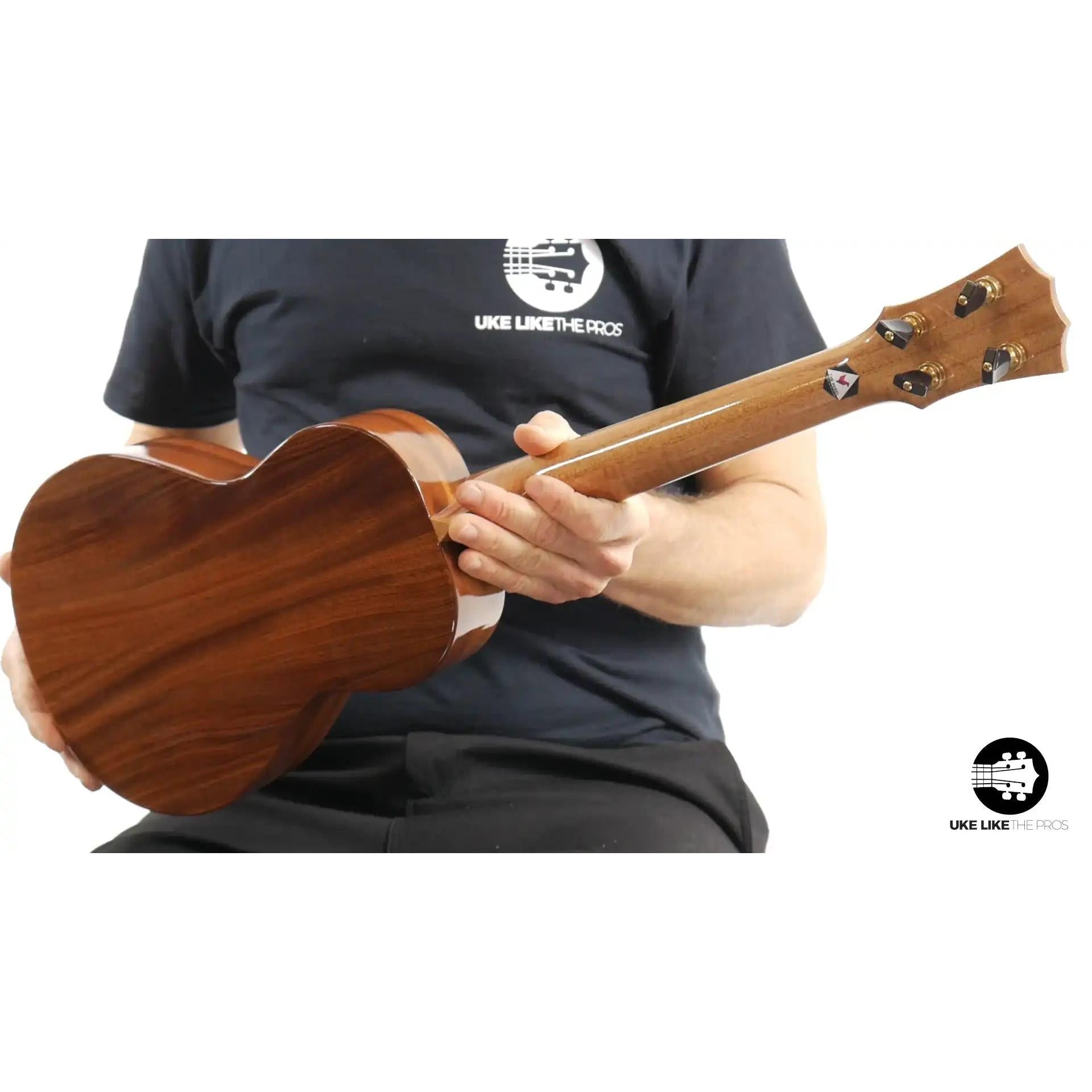 Back of a mahogany tenor ukulele held by a person, featured by Terry Carter Music Store.