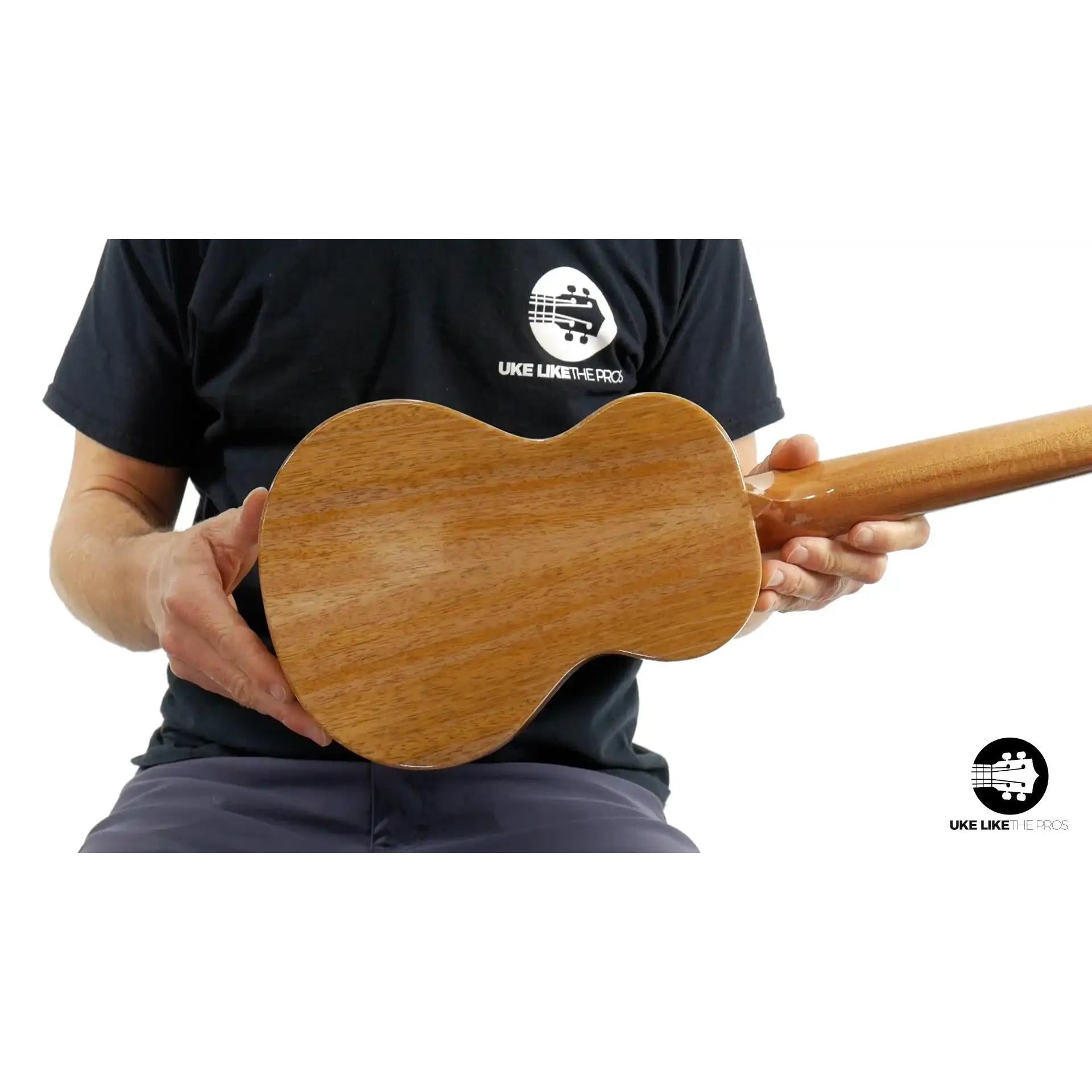 Back of Rebel ukulele in natural wood finish held by person, Terry Carter Music Store
