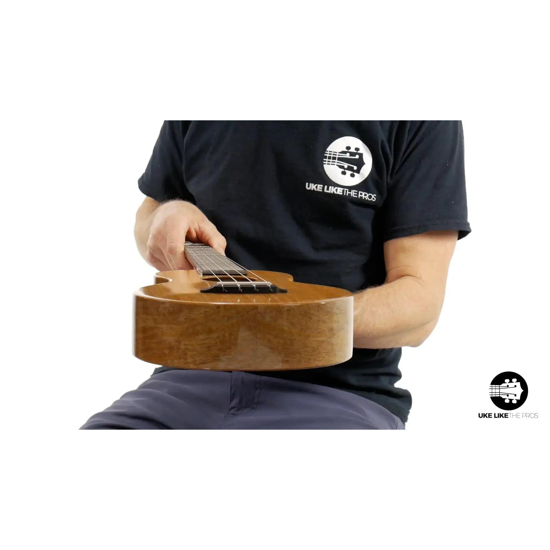 Person holding wood Rebel ukulele, maple finish, close-up at Terry Carter Music Store