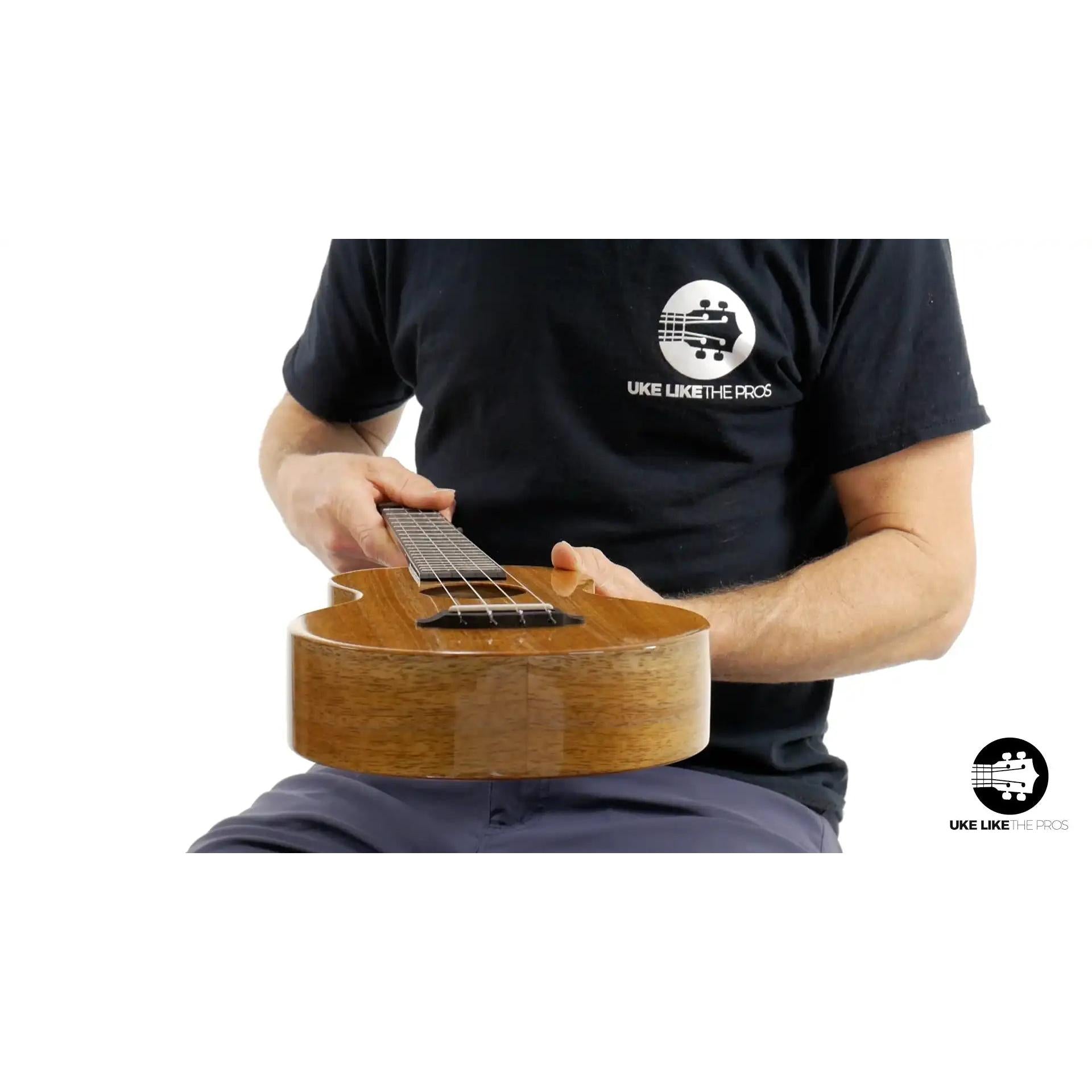 Rebel ukulele with natural wood finish held by person, Terry Carter Music Store product photo
