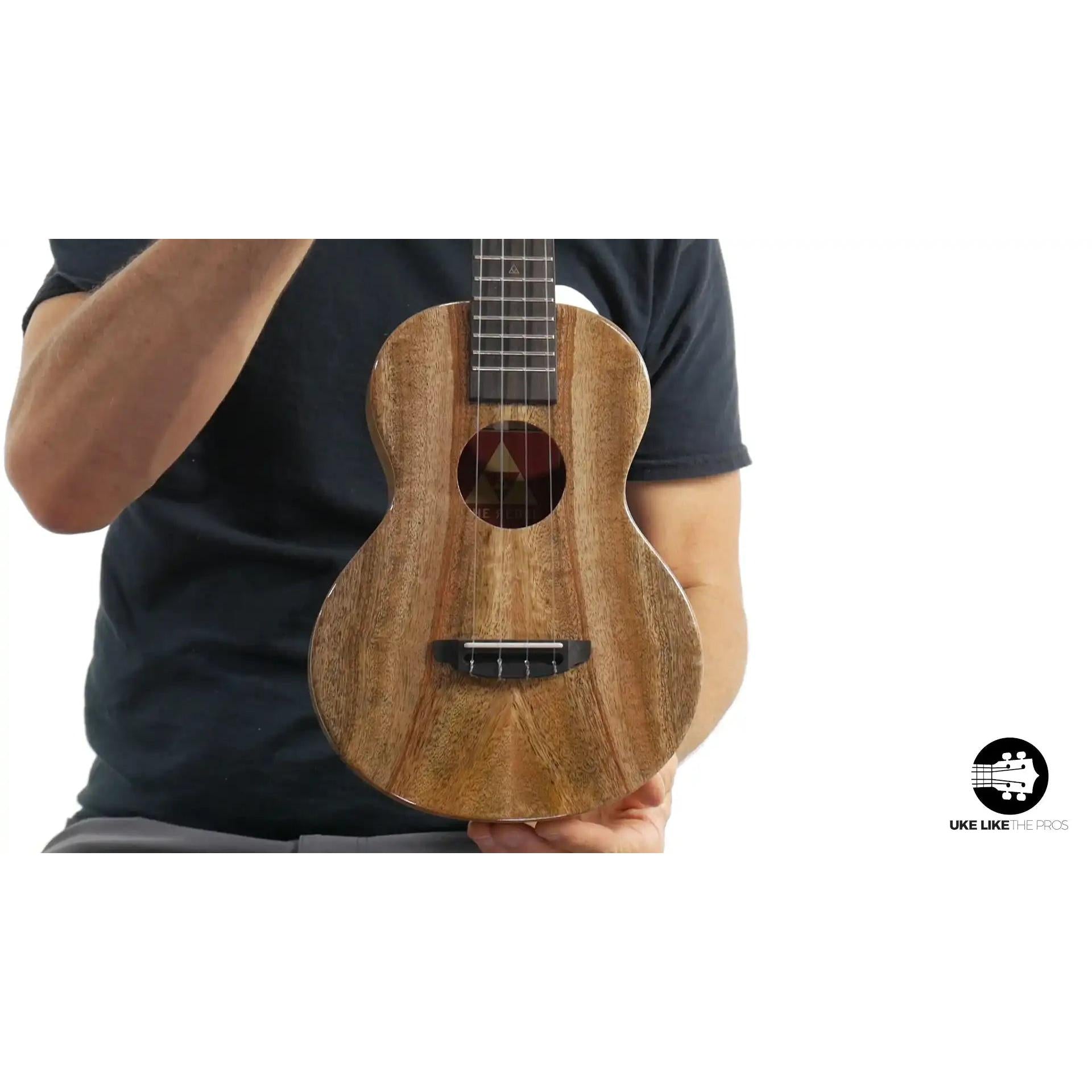 Rebel ukulele with natural wood grain body held by person, Terry Carter Music Store