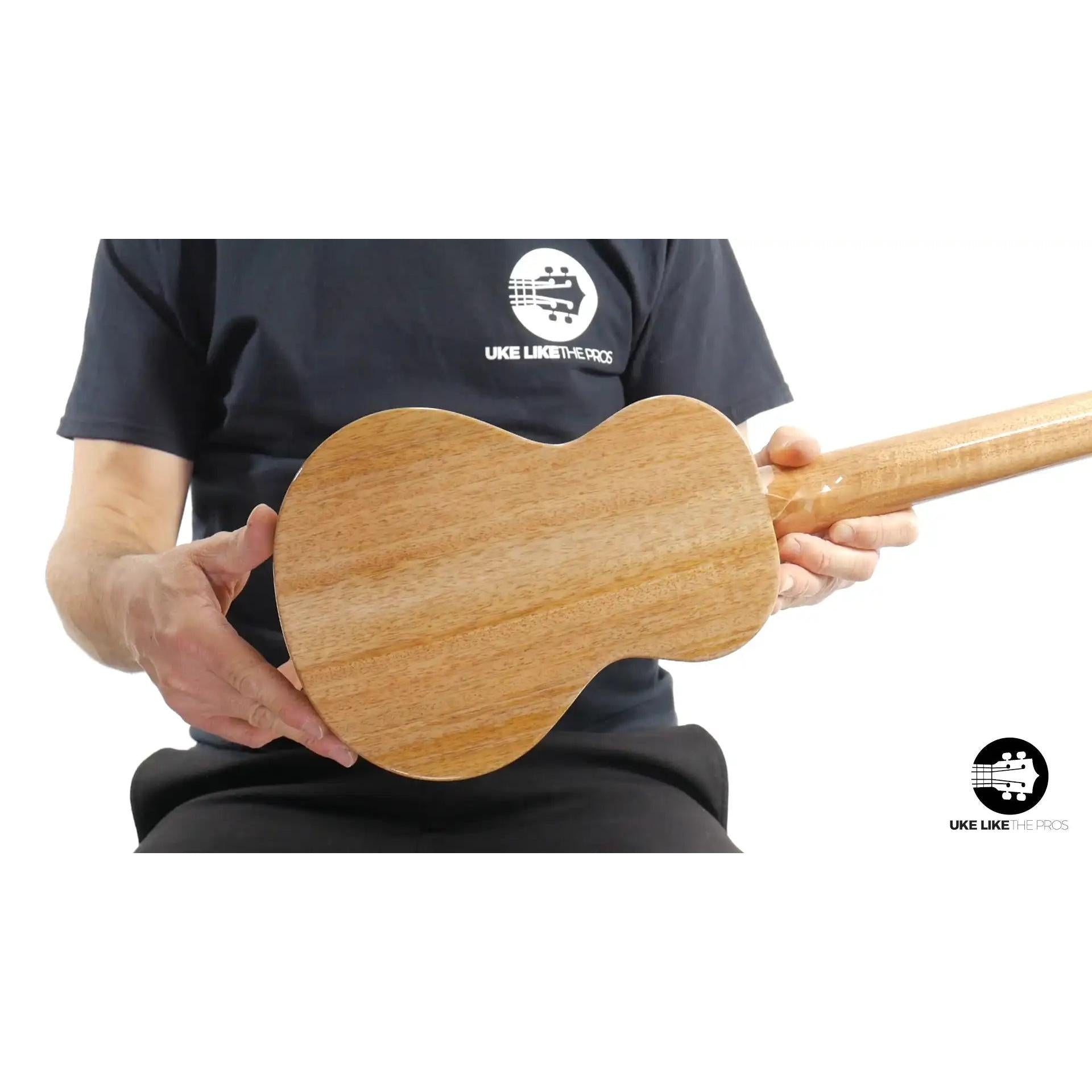 Back view of a light wood ukulele body held in hand at Terry Carter Music Store.