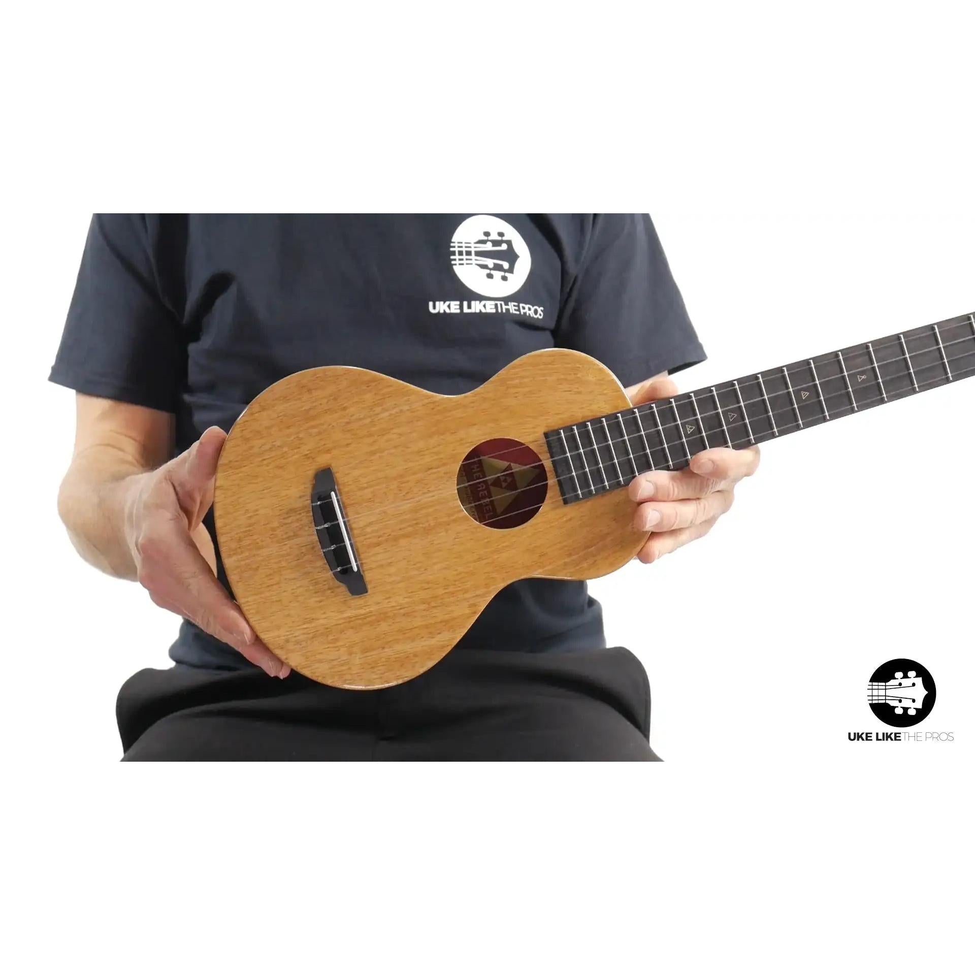 Person holding Rebel Mango Magic ukulele with natural wood finish at Terry Carter Music Store