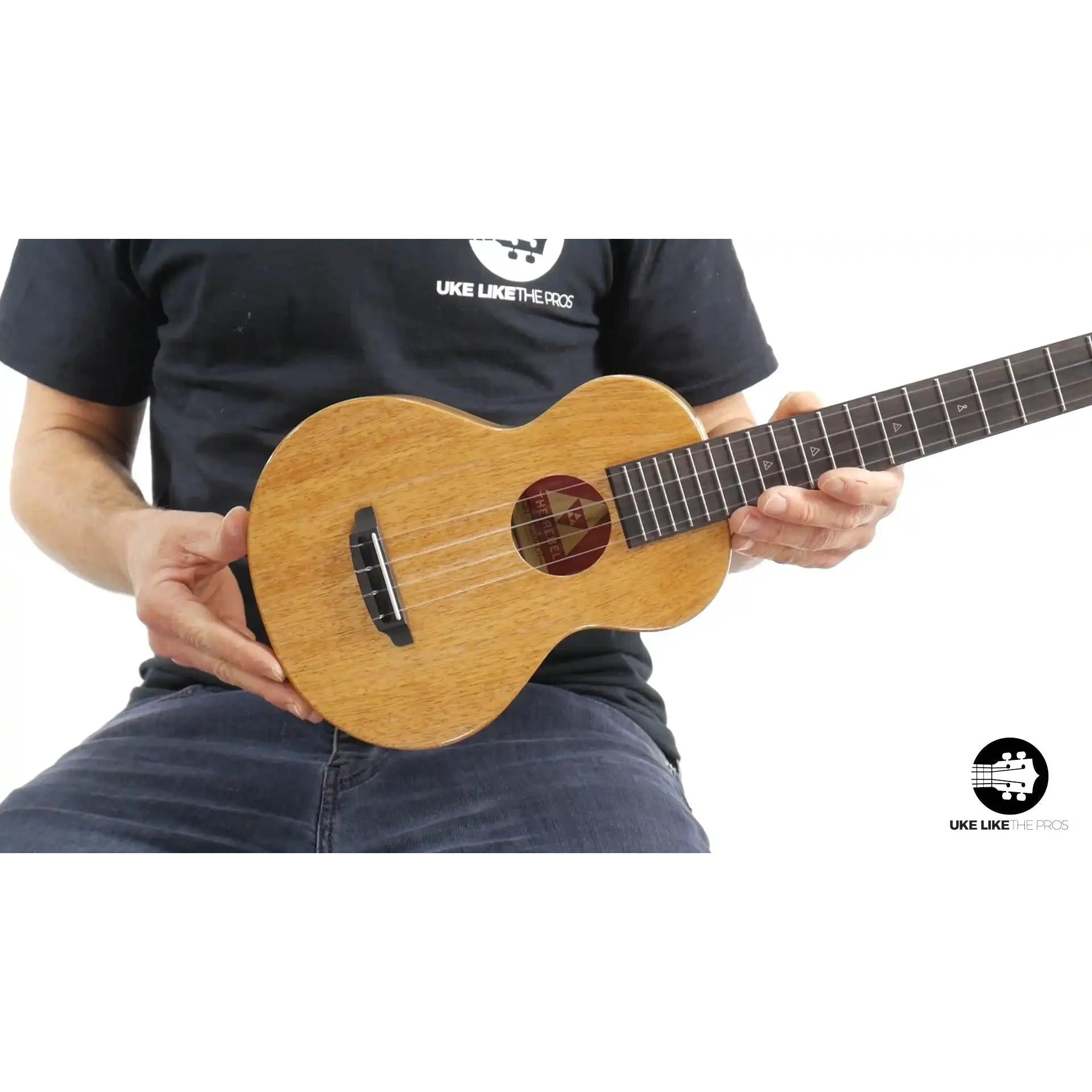 Rebel Double Creme ukulele with natural wood finish held by musician, Terry Carter Music Store