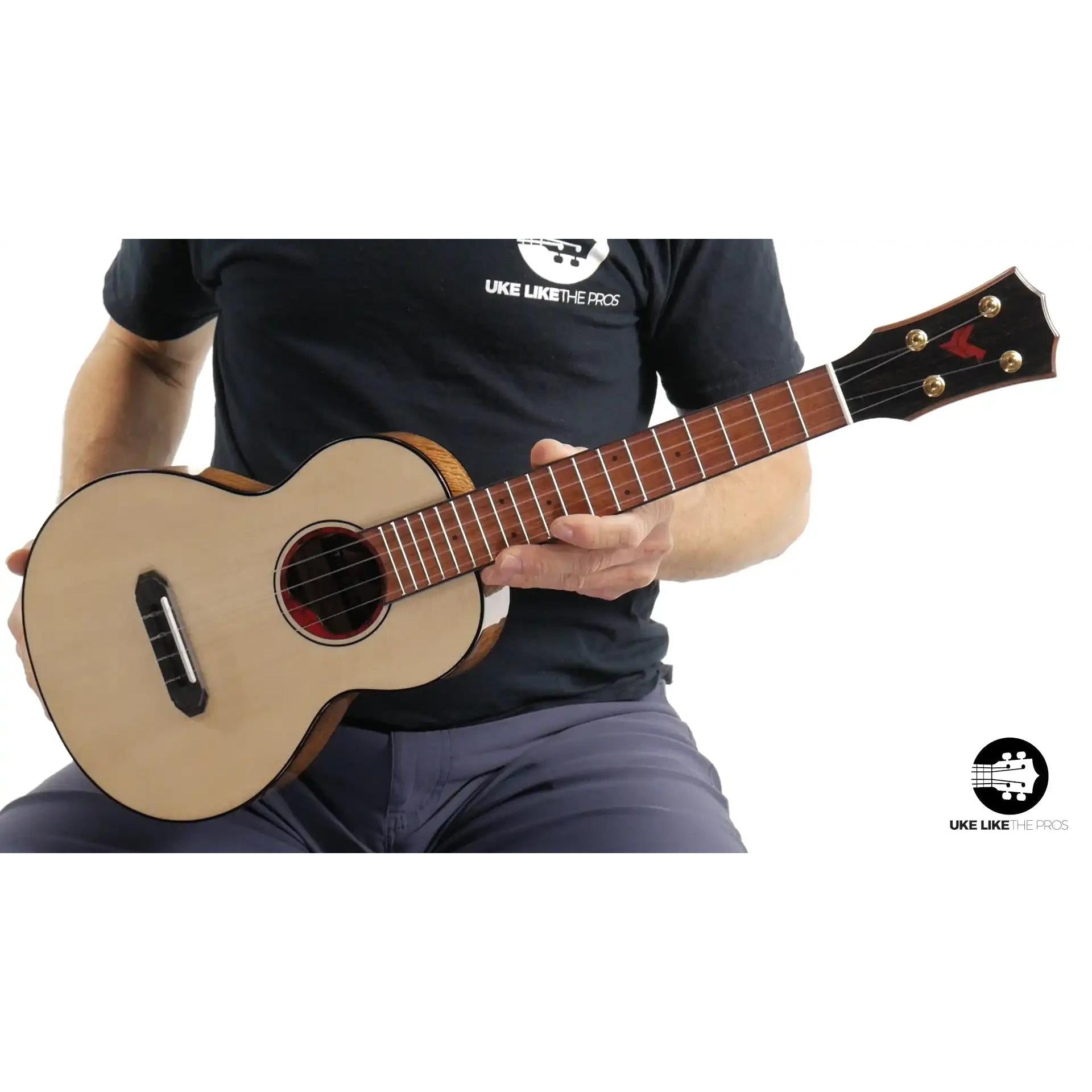 Rebel ukulele with natural wood finish, player holding instrument, Terry Carter Music Store