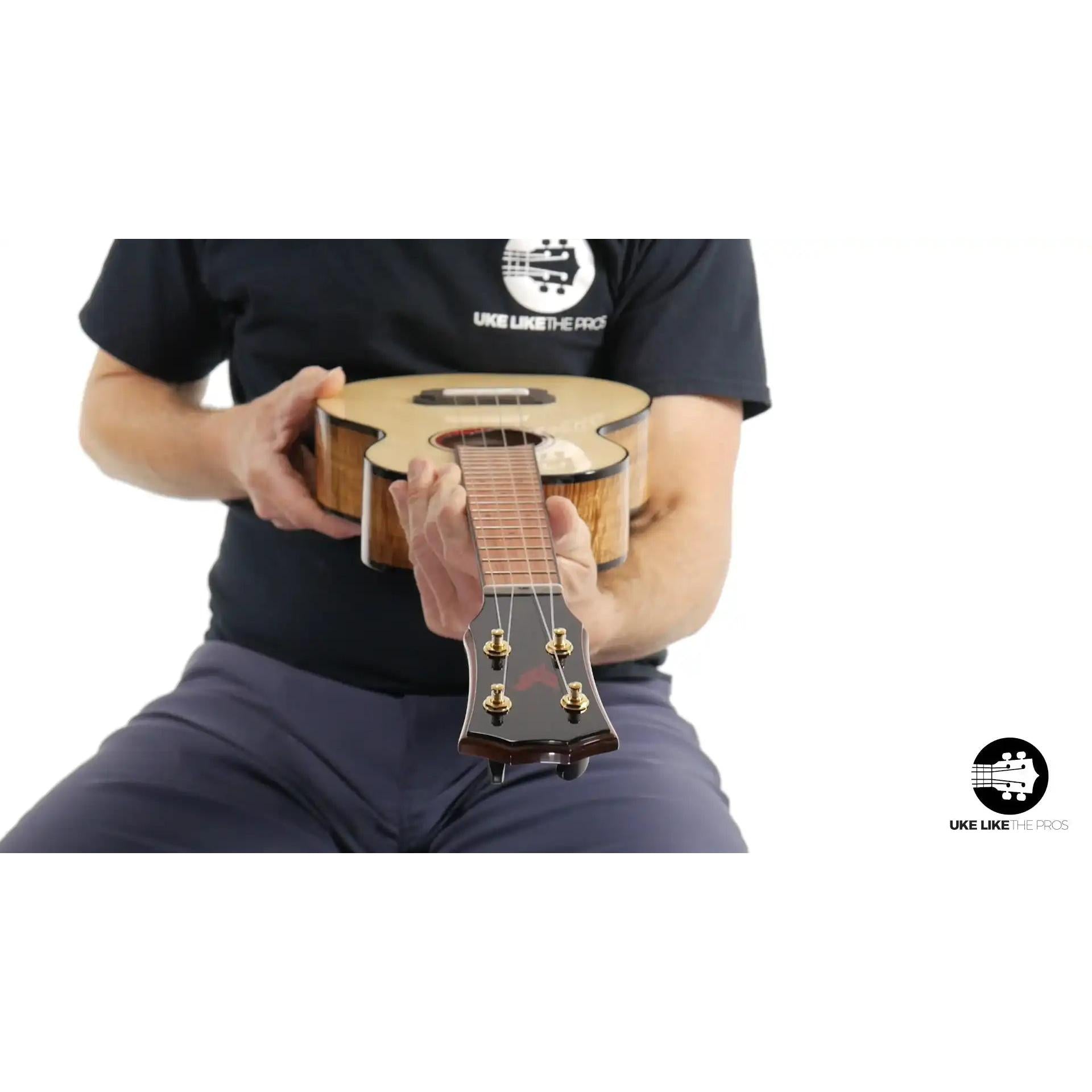 Rebel ukulele with figured wood top and gloss finish, held by a person, Terry Carter Music Store