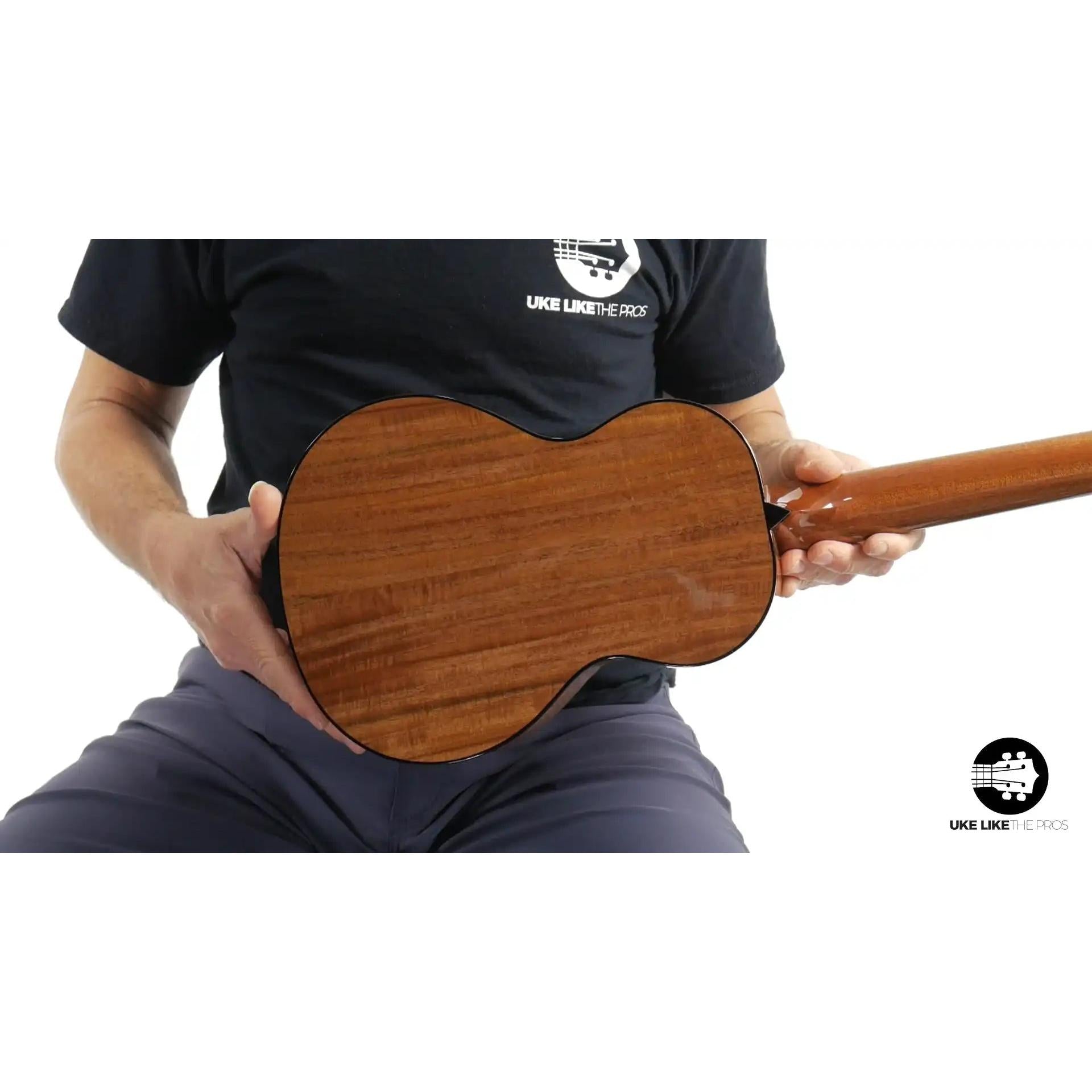 Back view of Rebel ukulele with rich brown wood grain, showcased at Terry Carter Music Store.