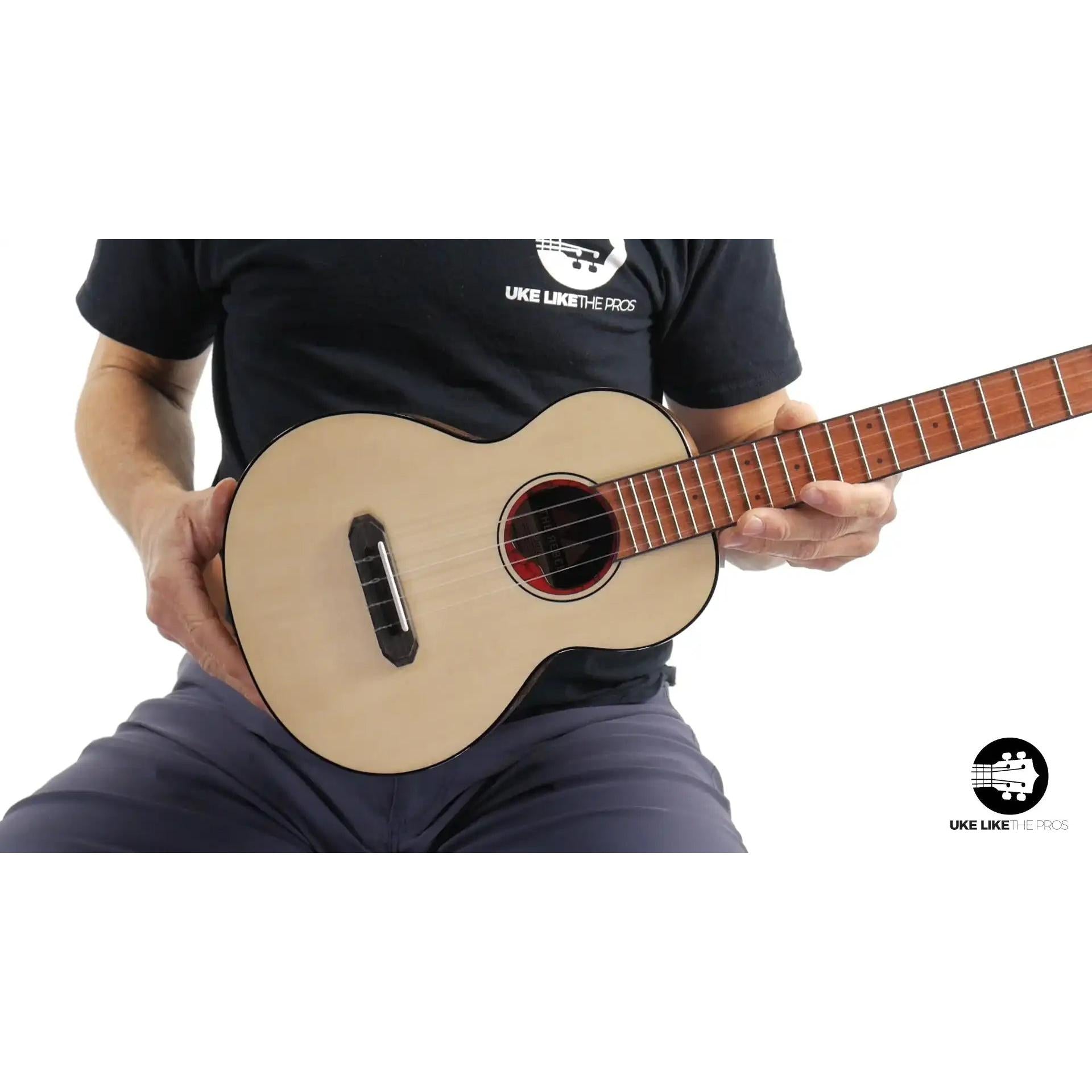 Rebel ukulele with light wood top, played by person, Terry Carter Music Store