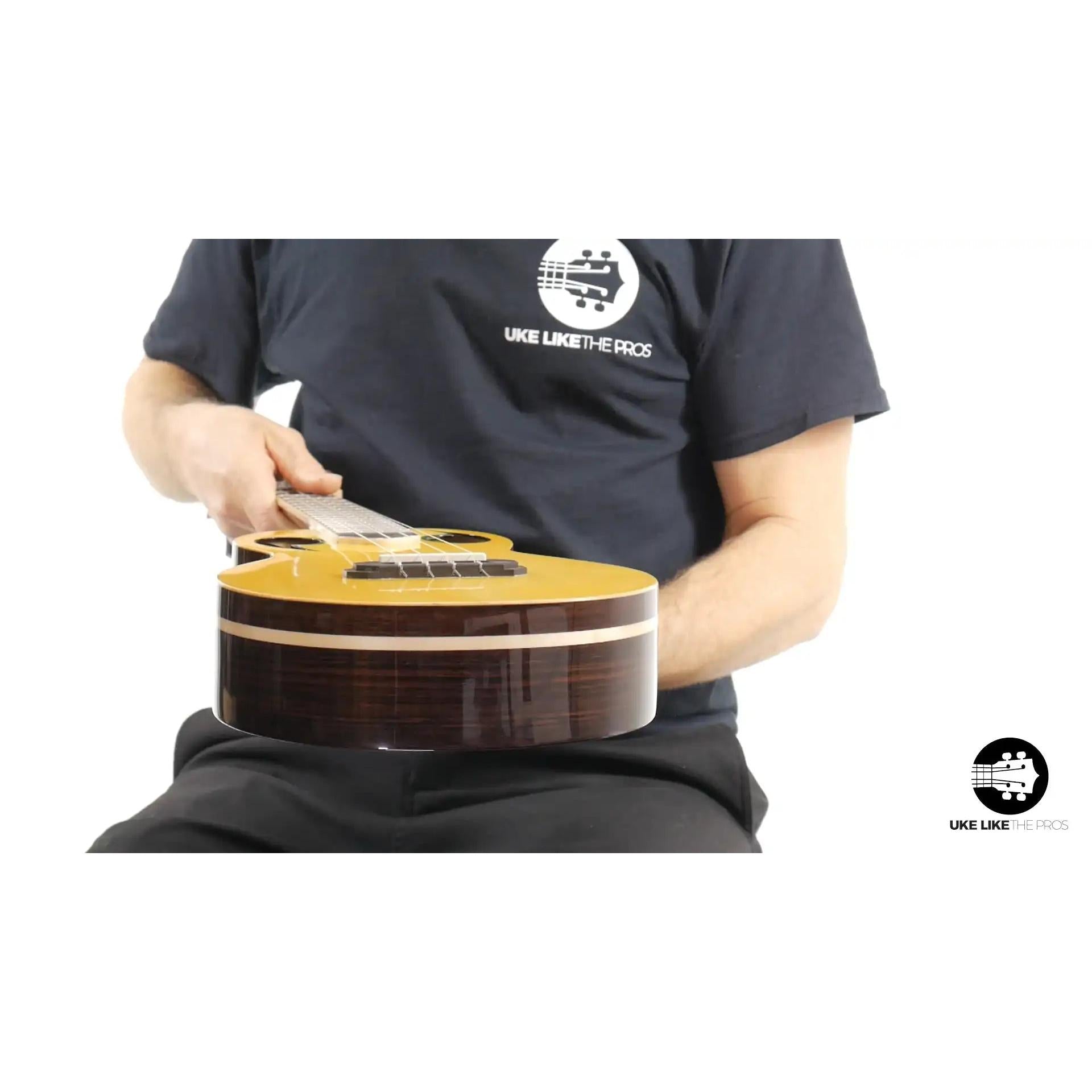 Person holding a Rebel Quark ukulele with gloss wood finish, featured at Terry Carter Music Store