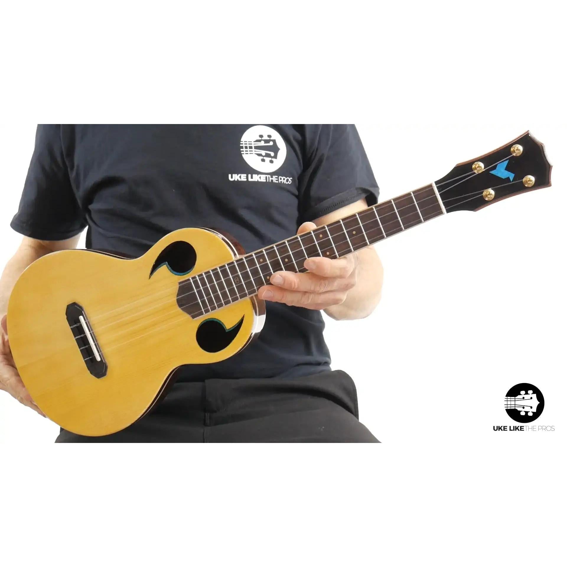 Rebel Quark ukulele spruce top with unique f-holes, held by player, Terry Carter Music Store