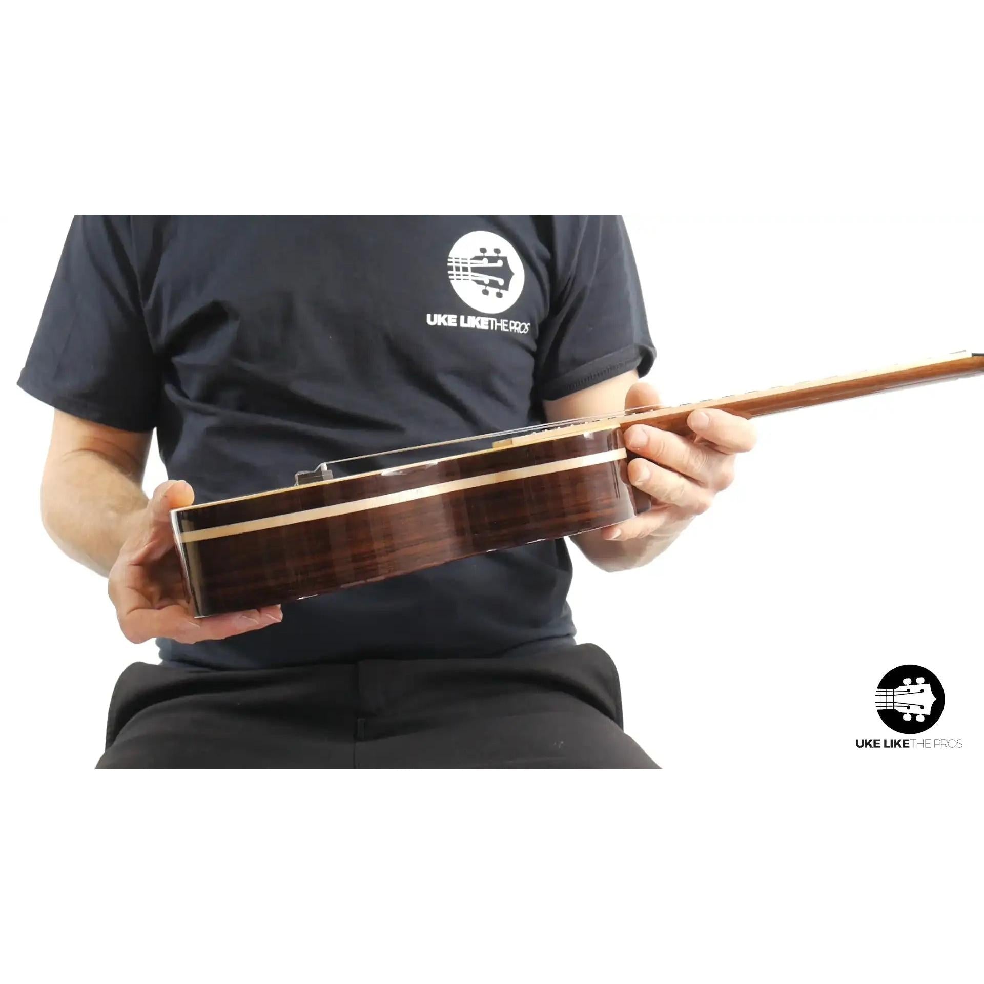 Side view of Rebel Quark ukulele with dark wood body, held by person, Terry Carter Music Store