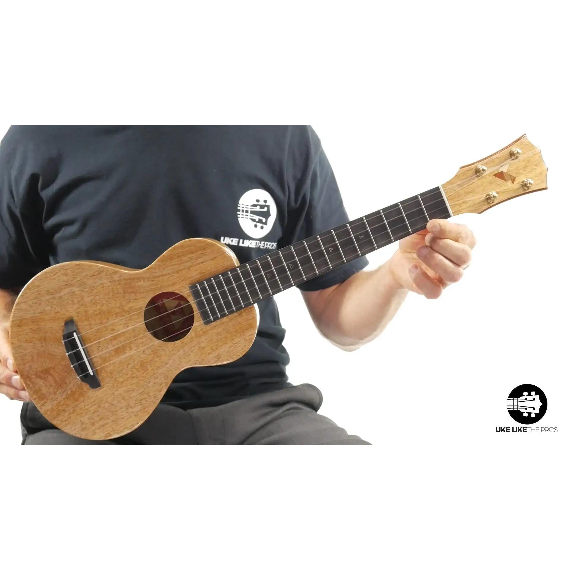 Butter brand natural wood ukulele held by a player, Terry Carter Music Store product photo