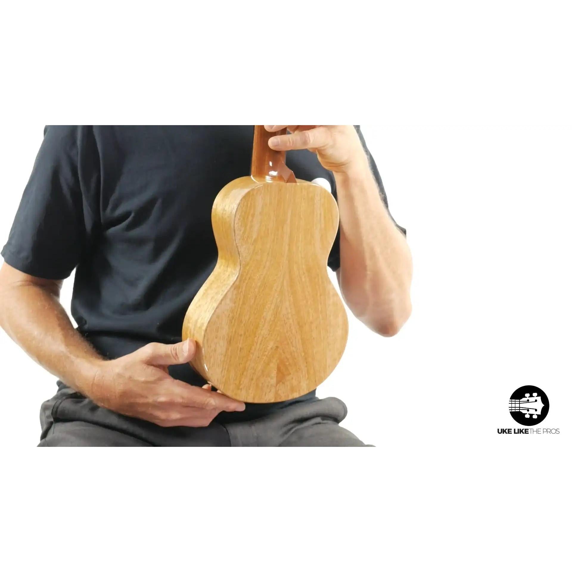 Back view of natural wood ukulele held by person, Terry Carter Music Store product photo