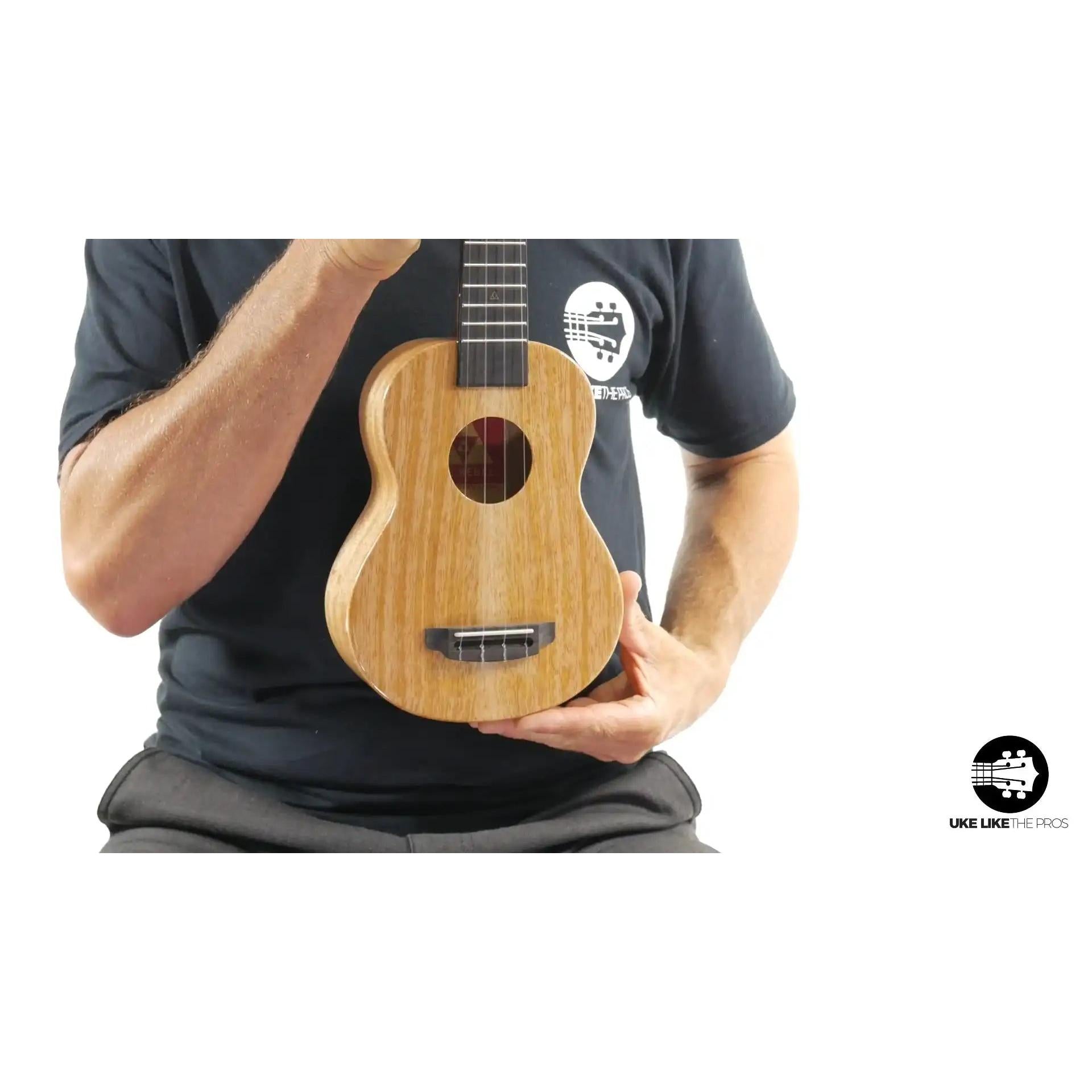 Little Giant ukulele with natural wood finish held upright, Terry Carter Music Store