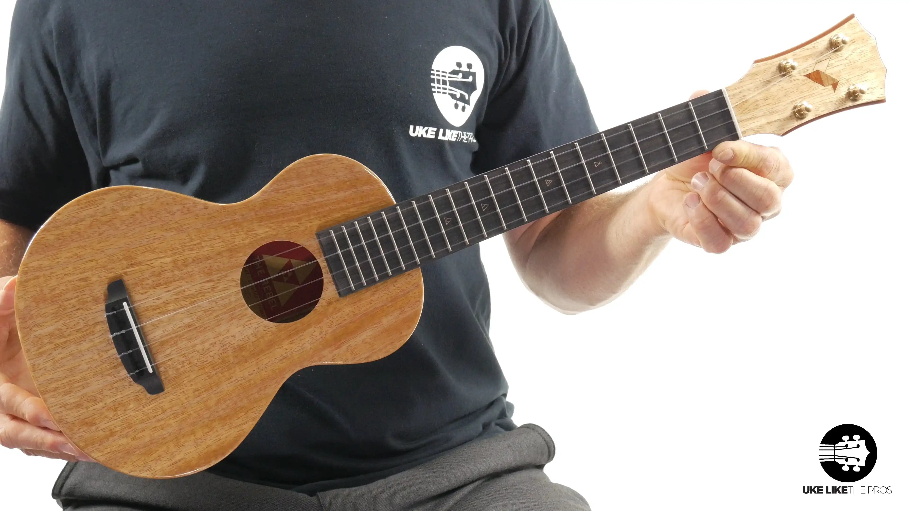 Romero Creations Rebel Double Creme natural wood ukulele held by a person, Terry Carter Music Store