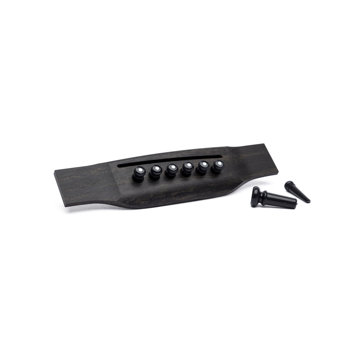 Martin black bridge pins with white dot inlay installed in a guitar bridge, with endpin beside it