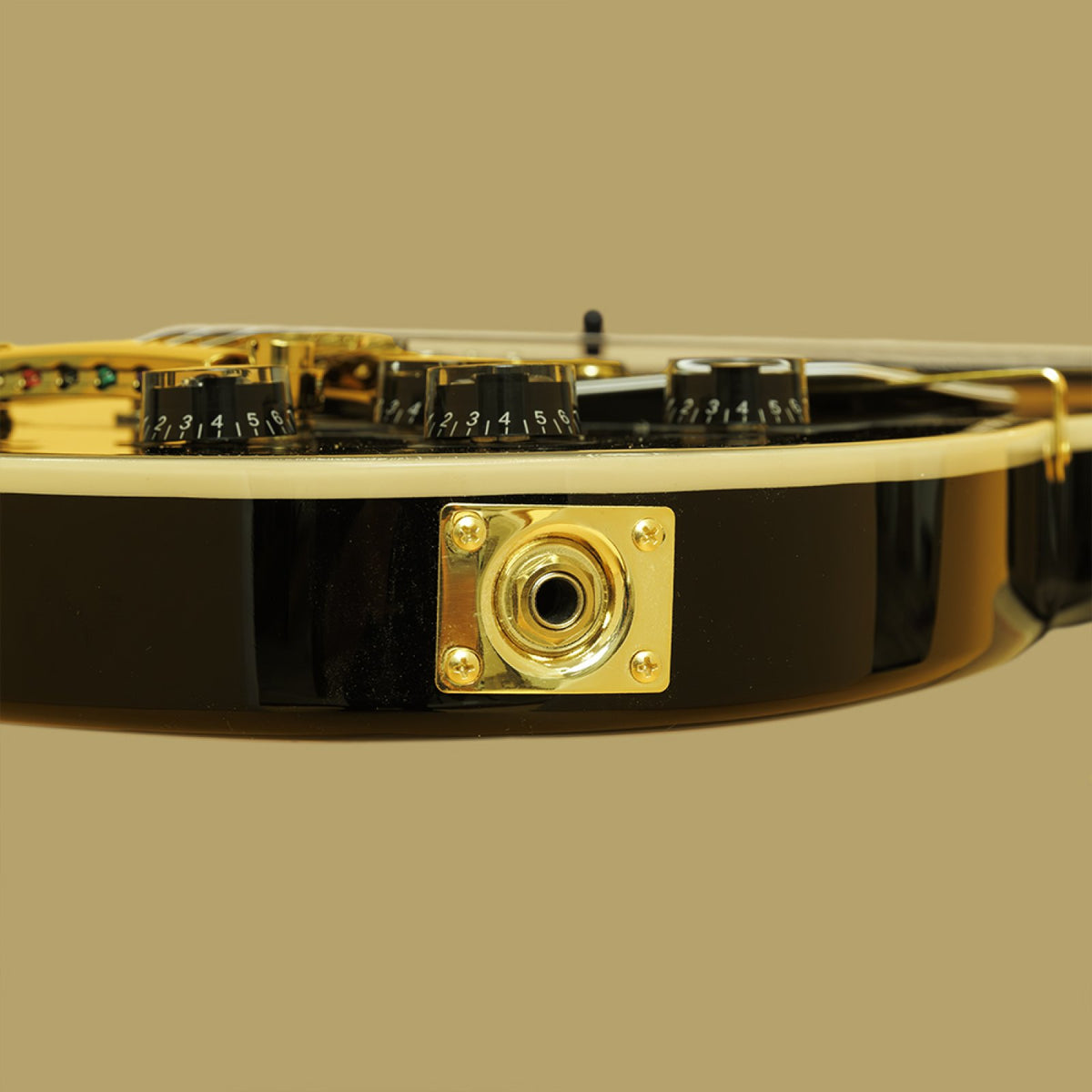 Gold output jack plate on the side of the black Stagg 30th Anniversary Legacy guitar