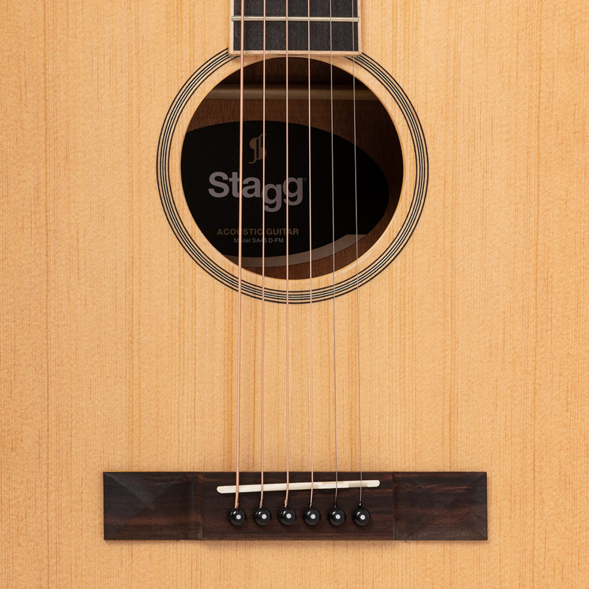 Close-up of the spruce top, soundhole rosette and rosewood bridge on the Stagg SA45 D-FM guitar