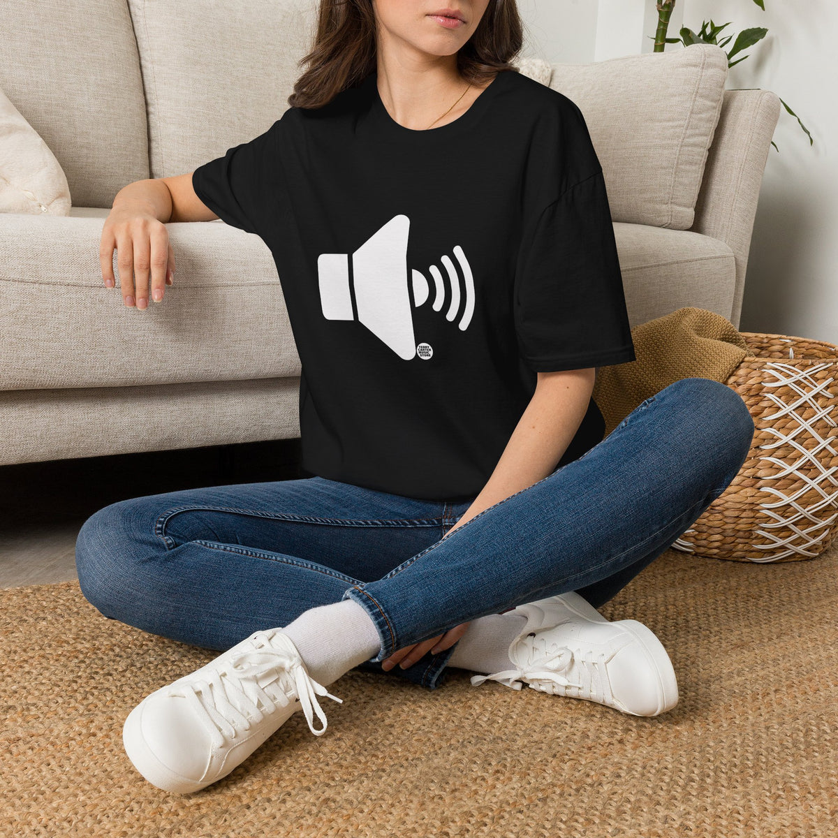 Sound On Speaker Icon black t-shirt, worn by a woman sitting on the floor by a couch