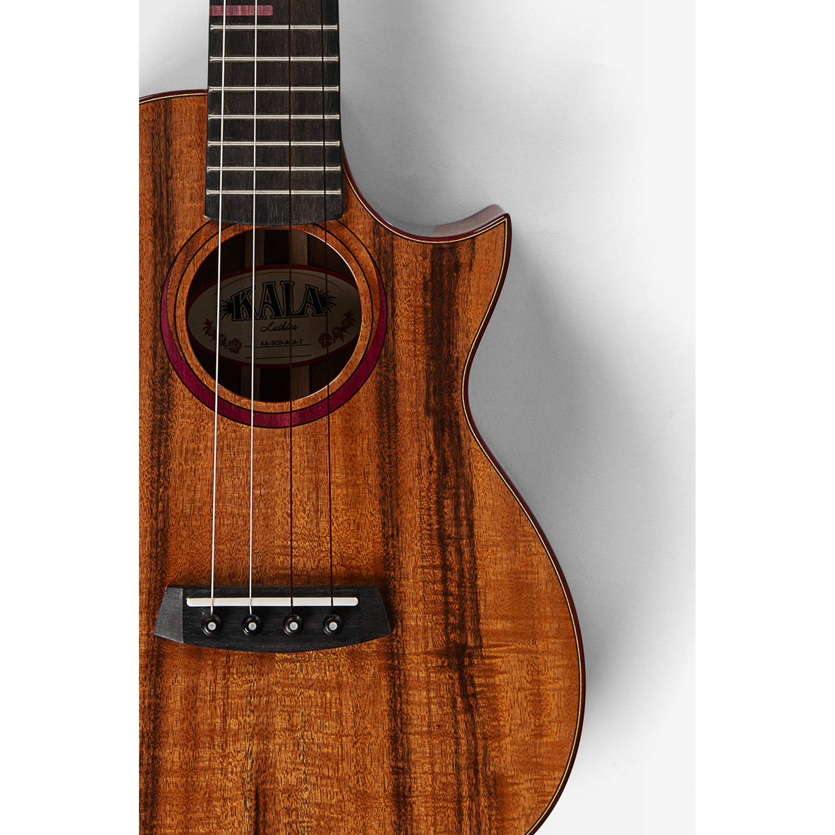 Kala KA-3CD-ACA-T body front close-up, figured solid acacia top with koa and purpleheart rosette and ebony bridge