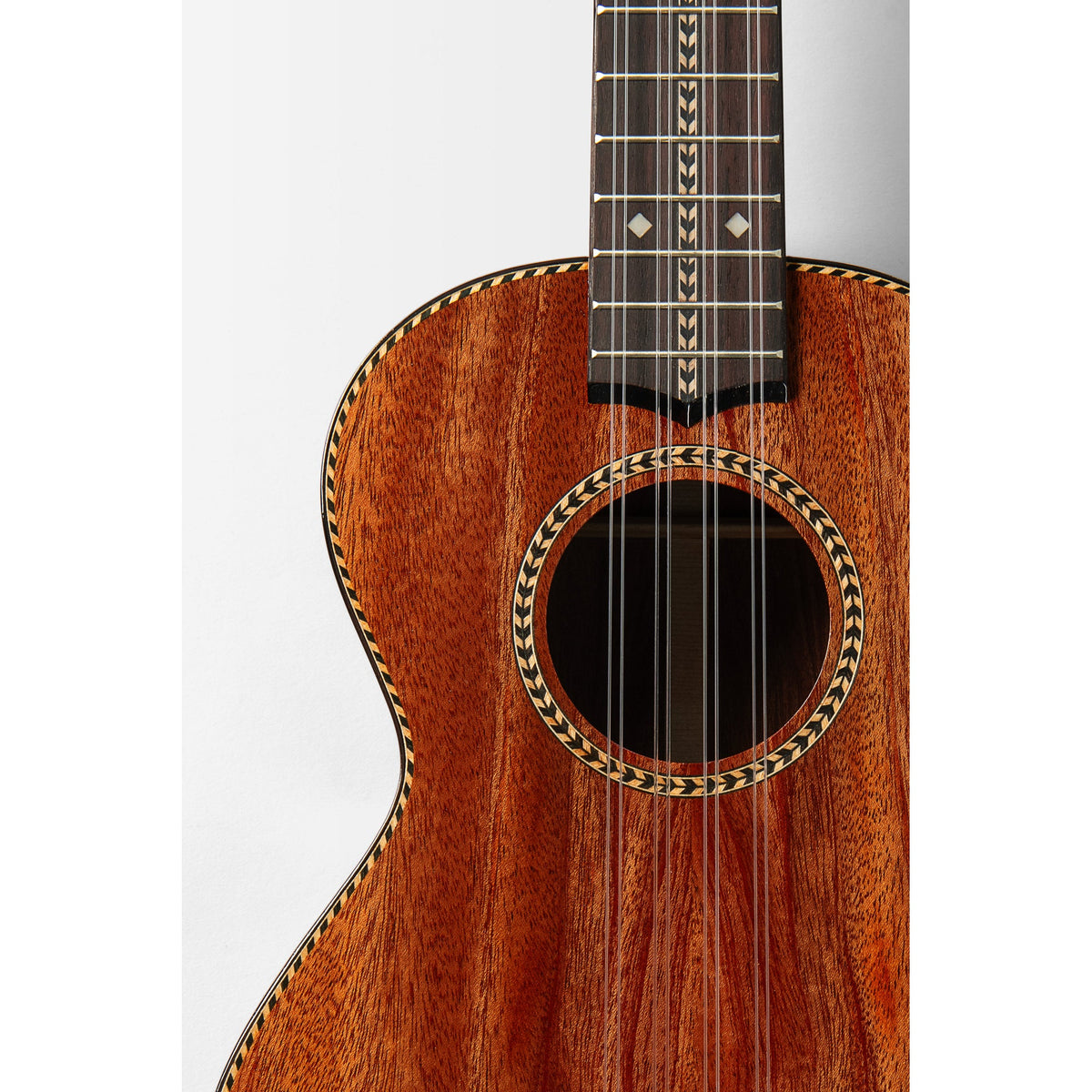 Kala KA-TARO-ASMH-T body front close-up, solid mahogany top with herringbone rosette and rosewood bridge