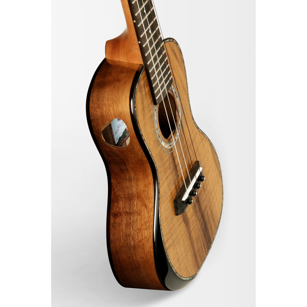 Angled view of the Kala KA-WCW-MYR-C showing the gloss walnut sides and mahogany armrest
