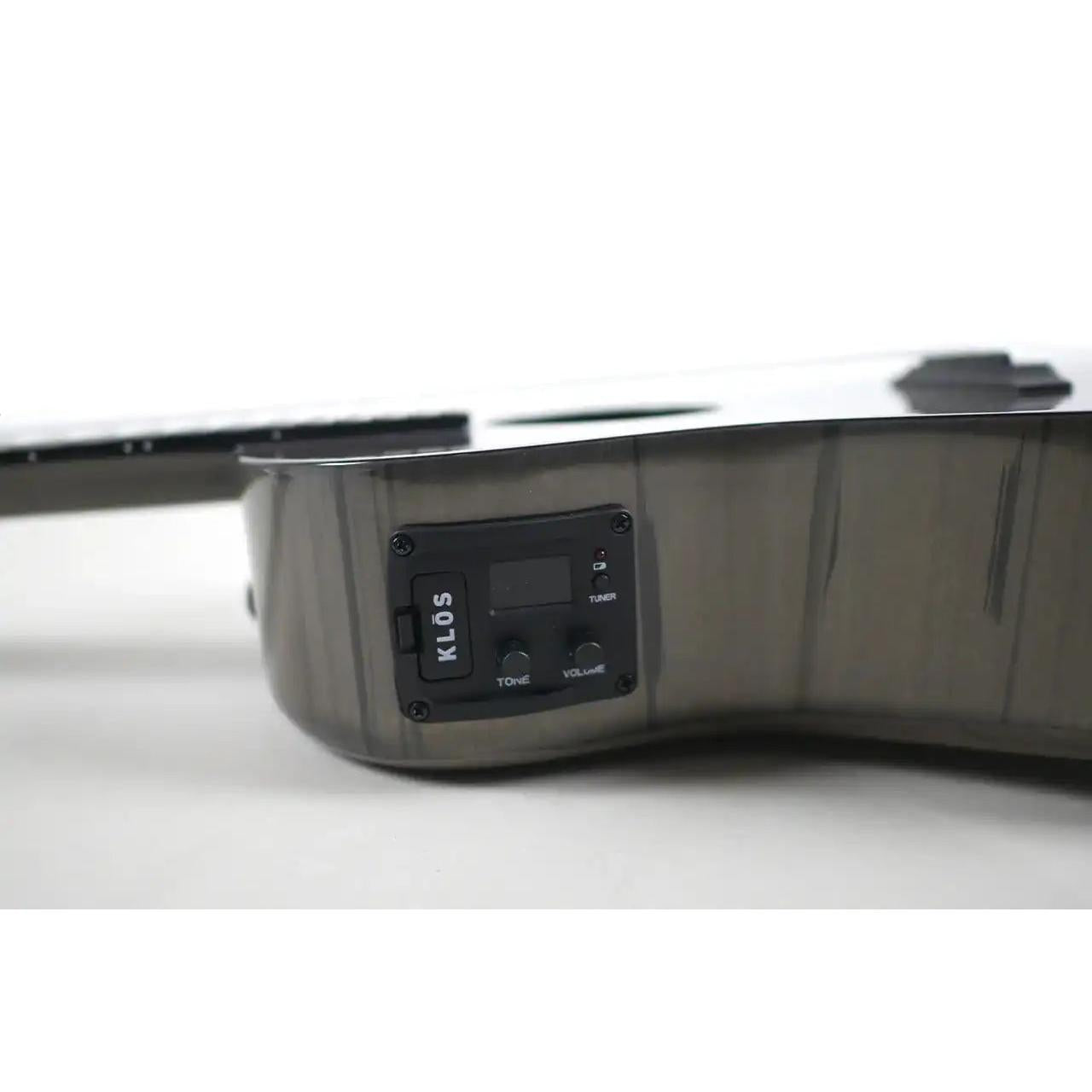Klōs Carbon Timber tenor ukulele side view featuring a built-in electronic tuner, tone, and volume control panel.