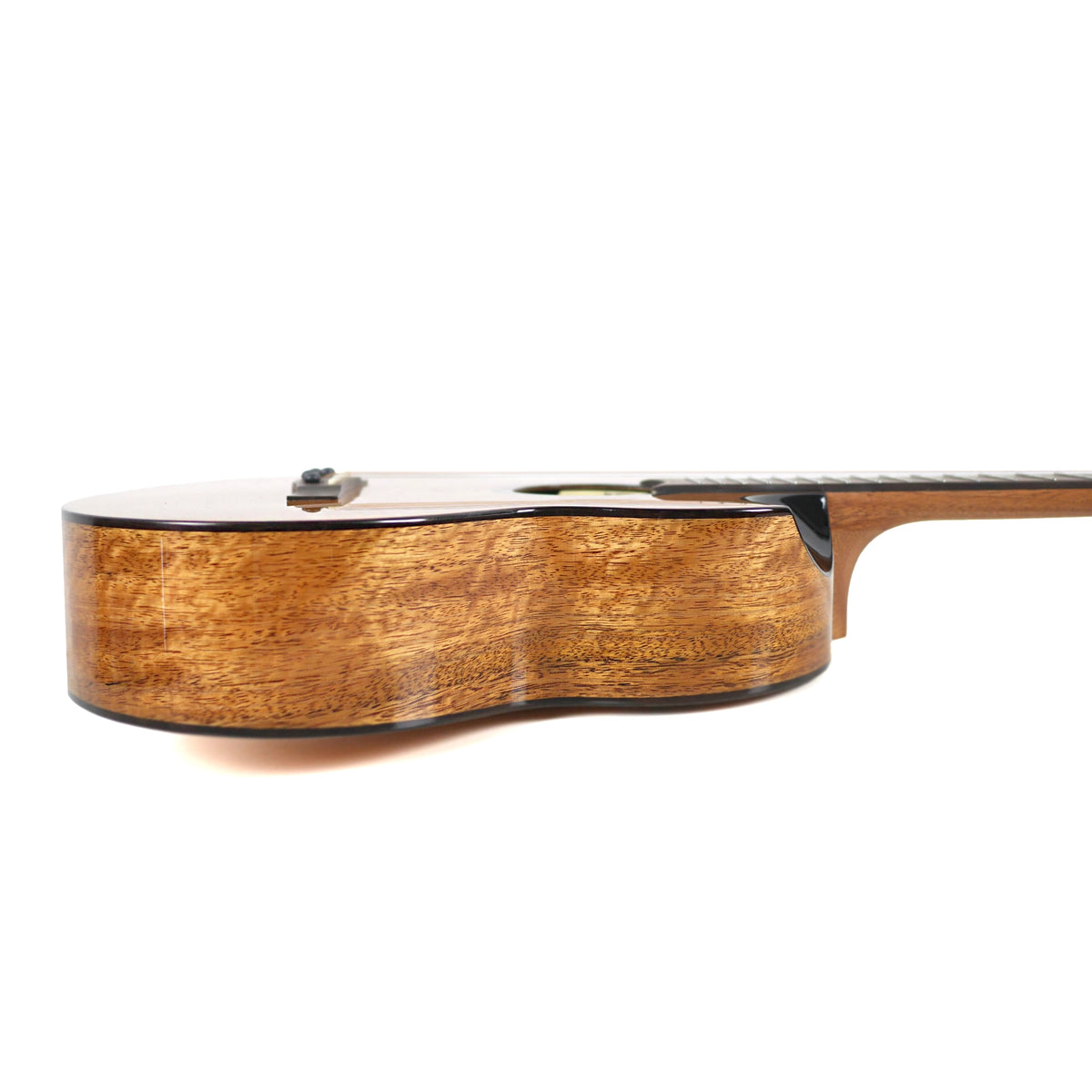 The side profile showcases the figured mango laminate sides and glossy finish of the Flight Lily Baritone.
