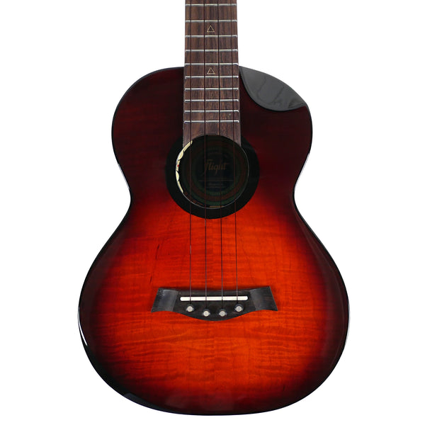 The close-up highlights the solid flamed maple top, pin bridge, and black armrest of the Flight Navigator Tenor.
